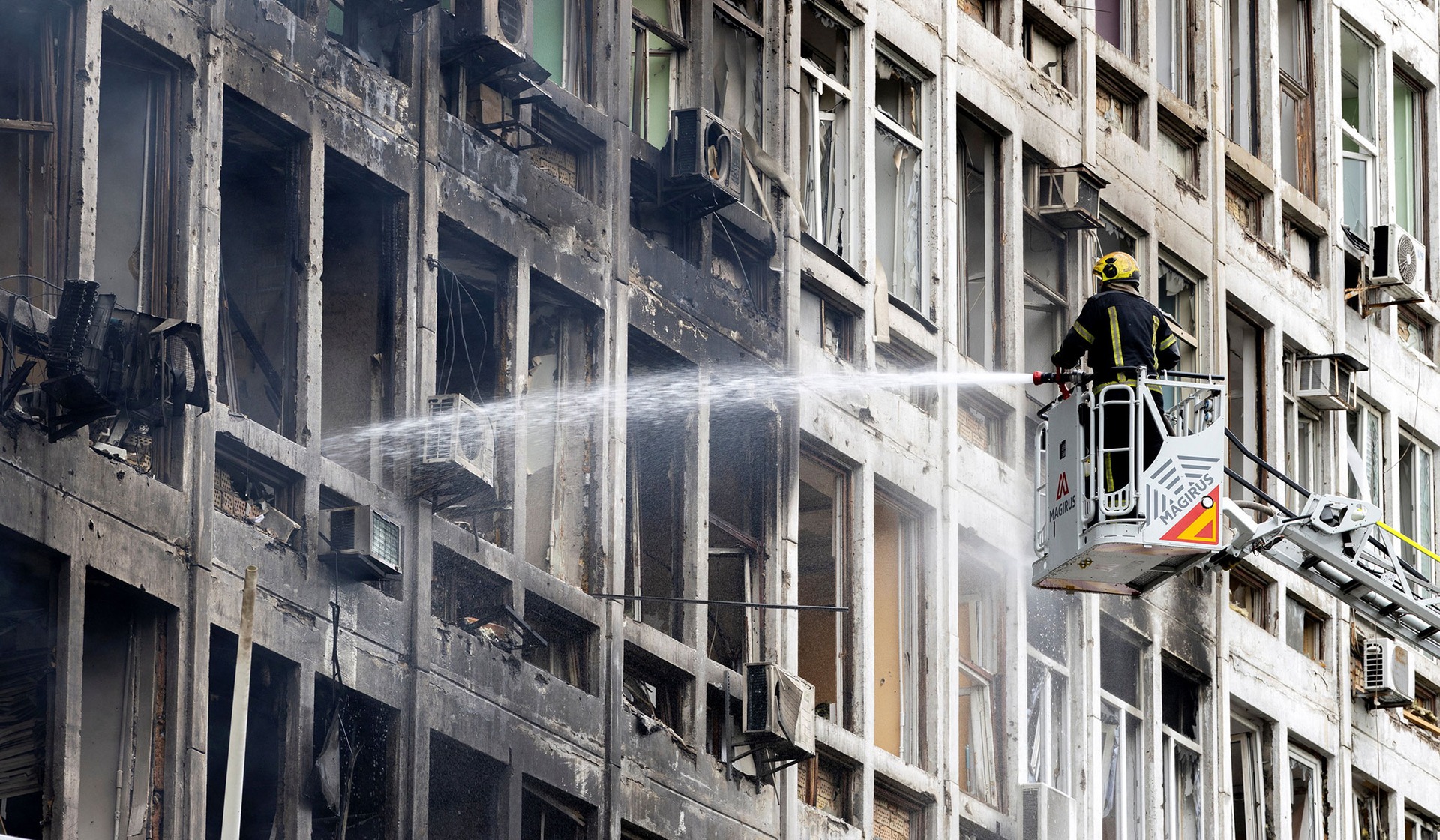 A firefighter works at the site of a business center that was struck by a Russian drone in Kyiv, Ukraine, September 23, 2026.