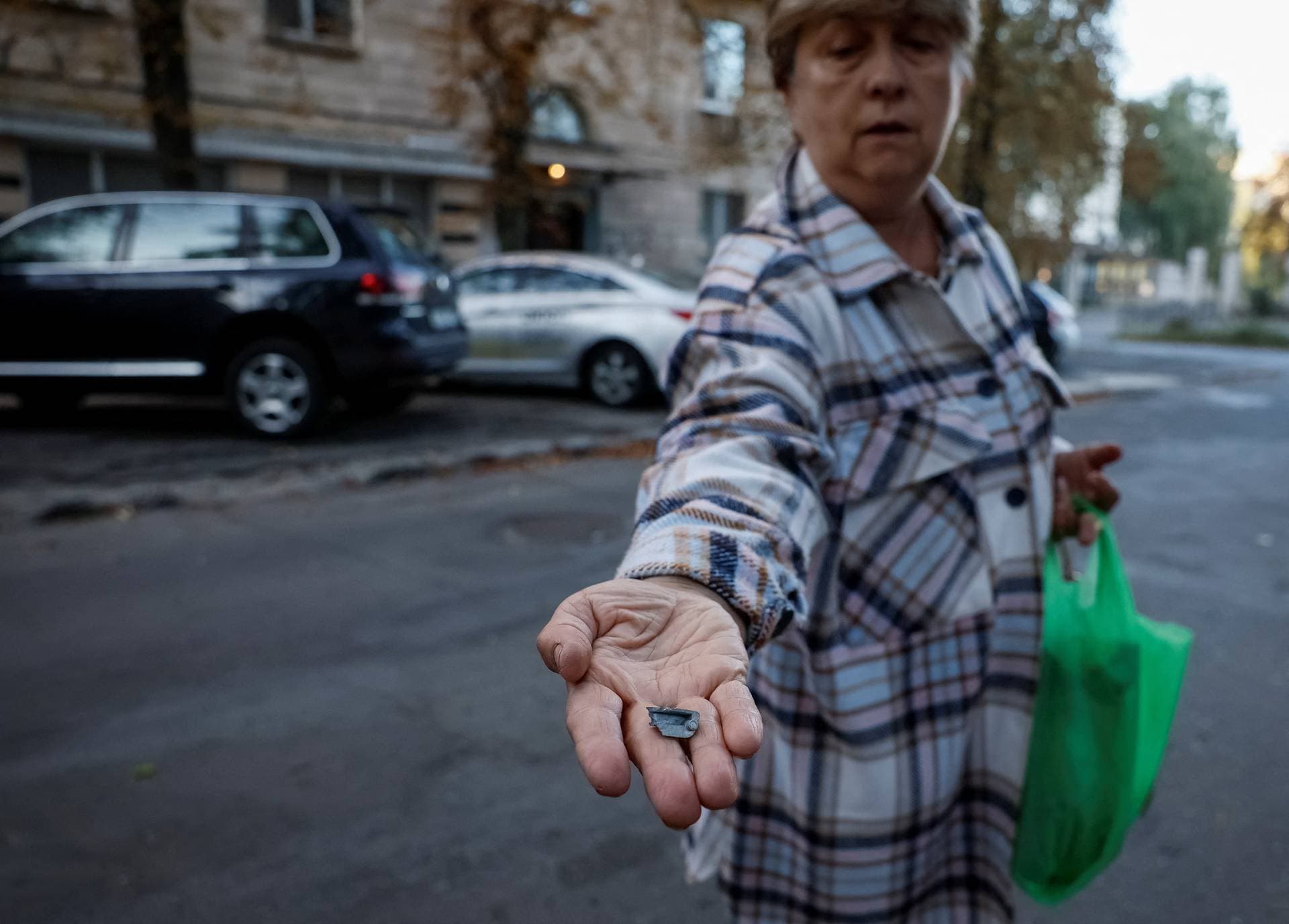 A local resident shows the splinter that hit her apartment during a Russian drone strike in Kyiv