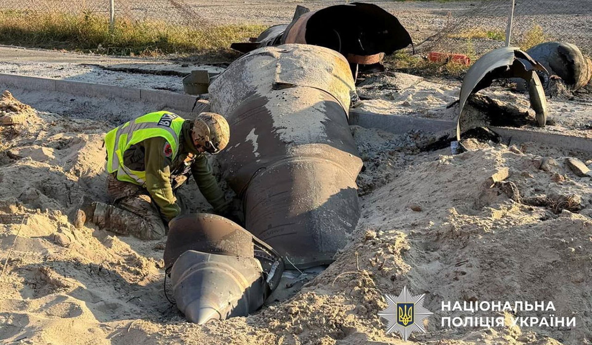 A police bomb squad member inspects an unexploded Russian missile warhead at the site of a Russian strike in Kyiv