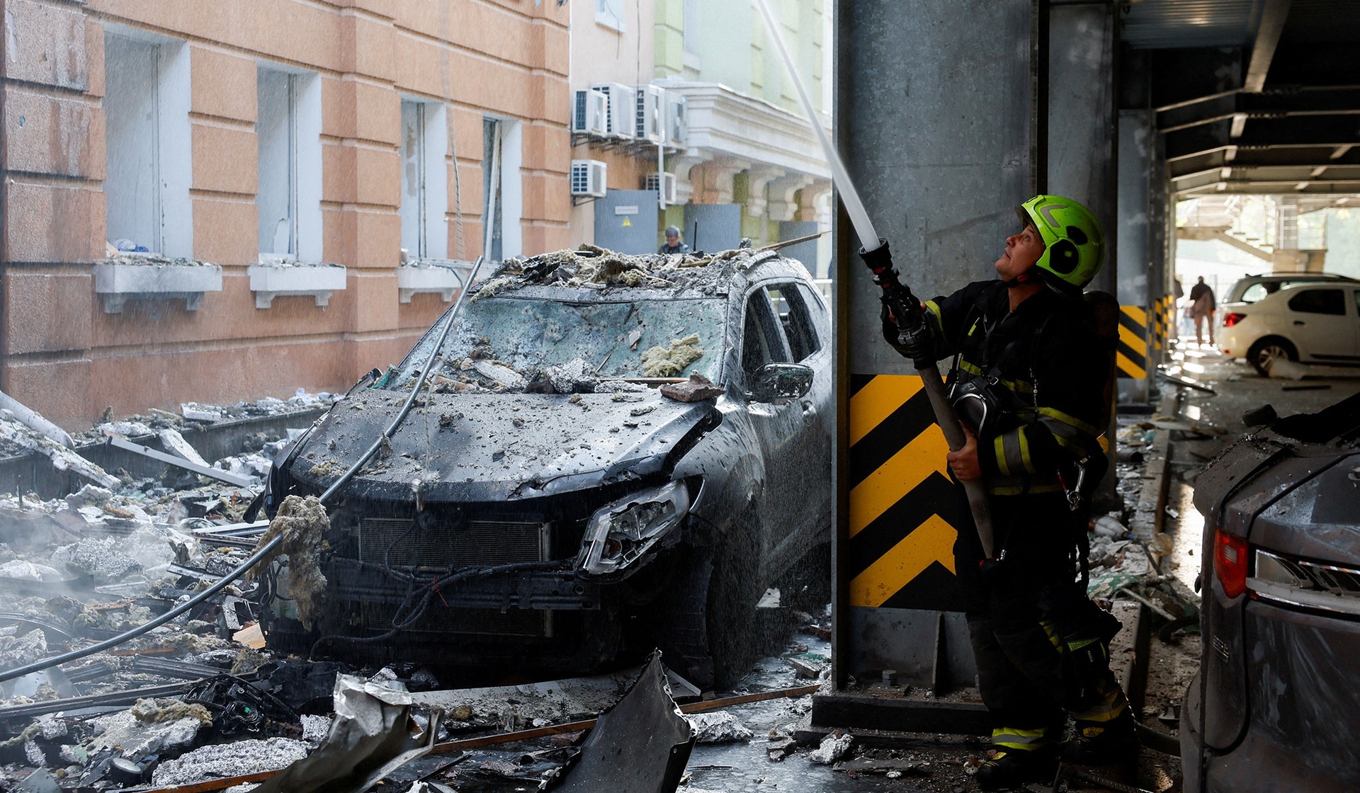 A firefighter works at the site of a business center hit by a Russian drone strike in Kyiv, Ukraine, September 23, 2026.