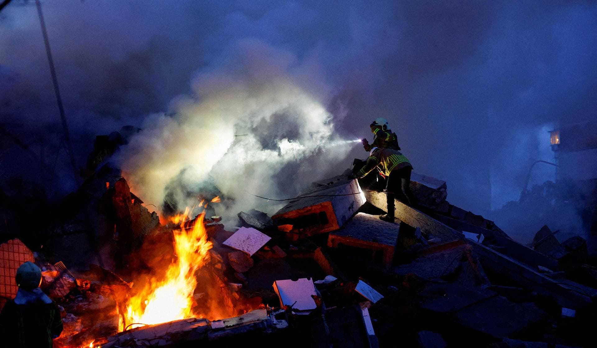 Rescuers work at the site of an apartment building damaged during Russian missile and drone strikes in Kyiv