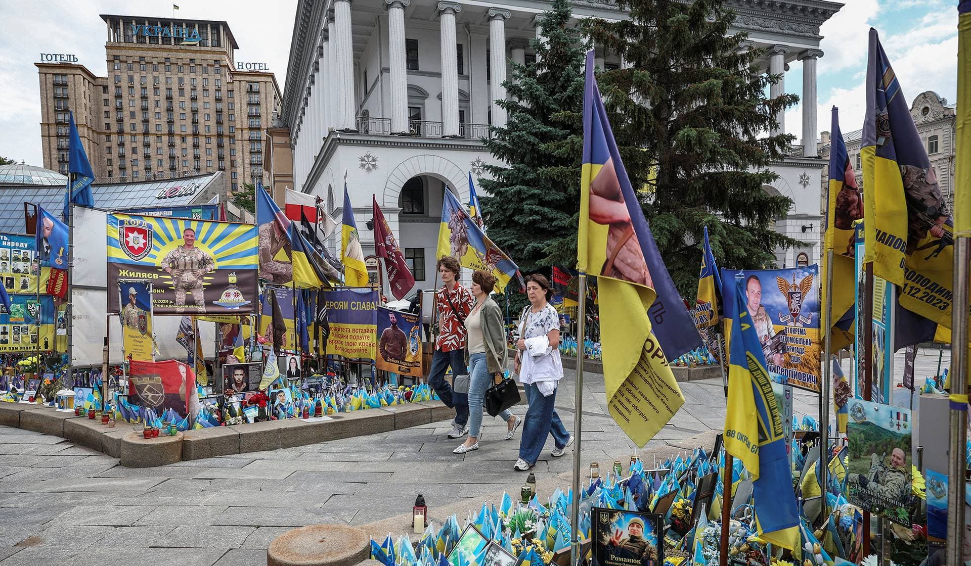 People walk near of the makeshift memorial to fallen Ukrainian defenders at Independence Square in central Kyiv