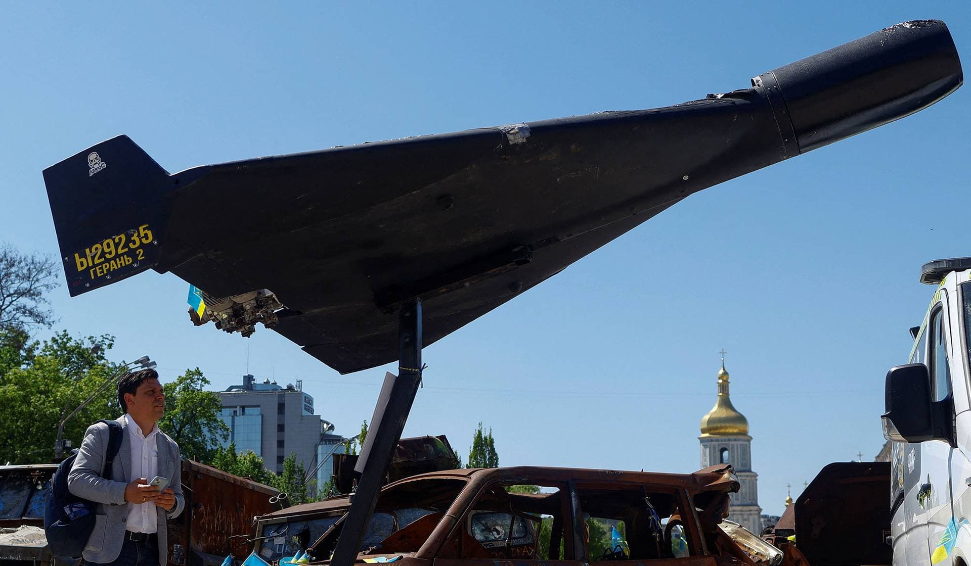 A resident looks at a kamikaze drone installed in front of Saint Michael's Cathedral as a part of an exhibition in Kyiv