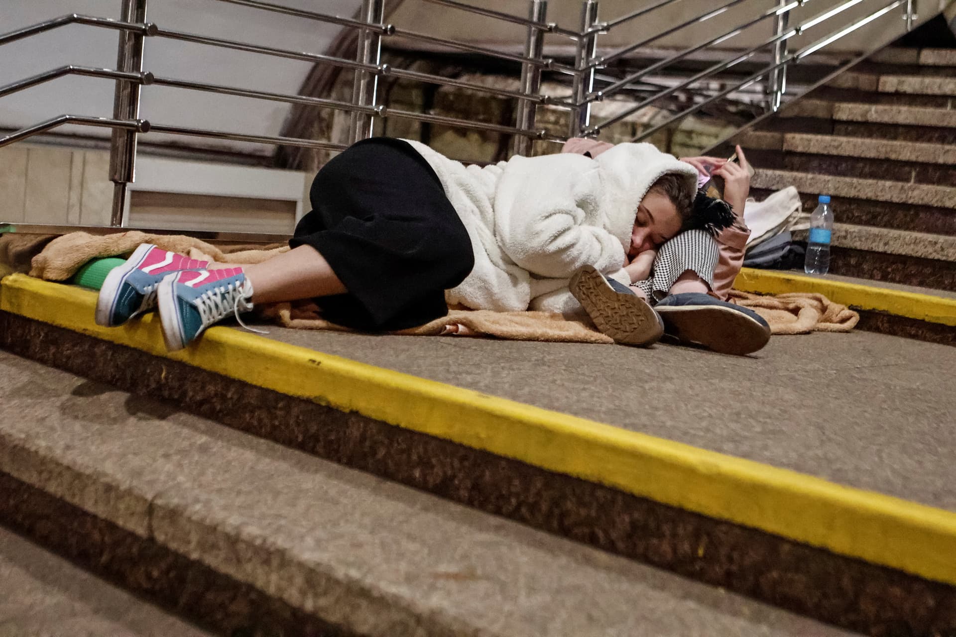 People sleep on stairs as they take shelter inside a metro station during an overnight Russian missile and drone strike, amid Russia's attack on Ukraine, in Kyiv