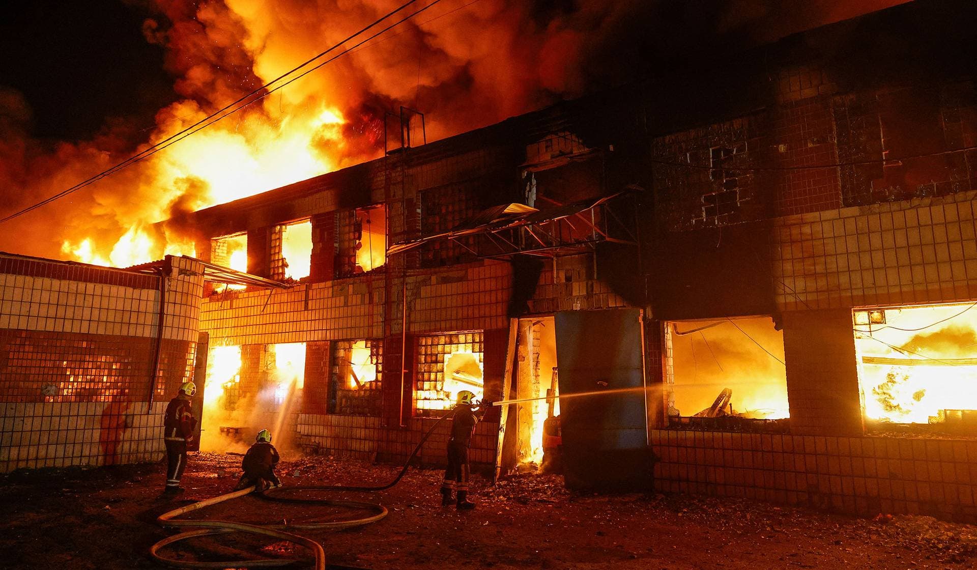 Firefighters work at a compound of a private enterprise damaged during Russian missile strikes in Kyiv