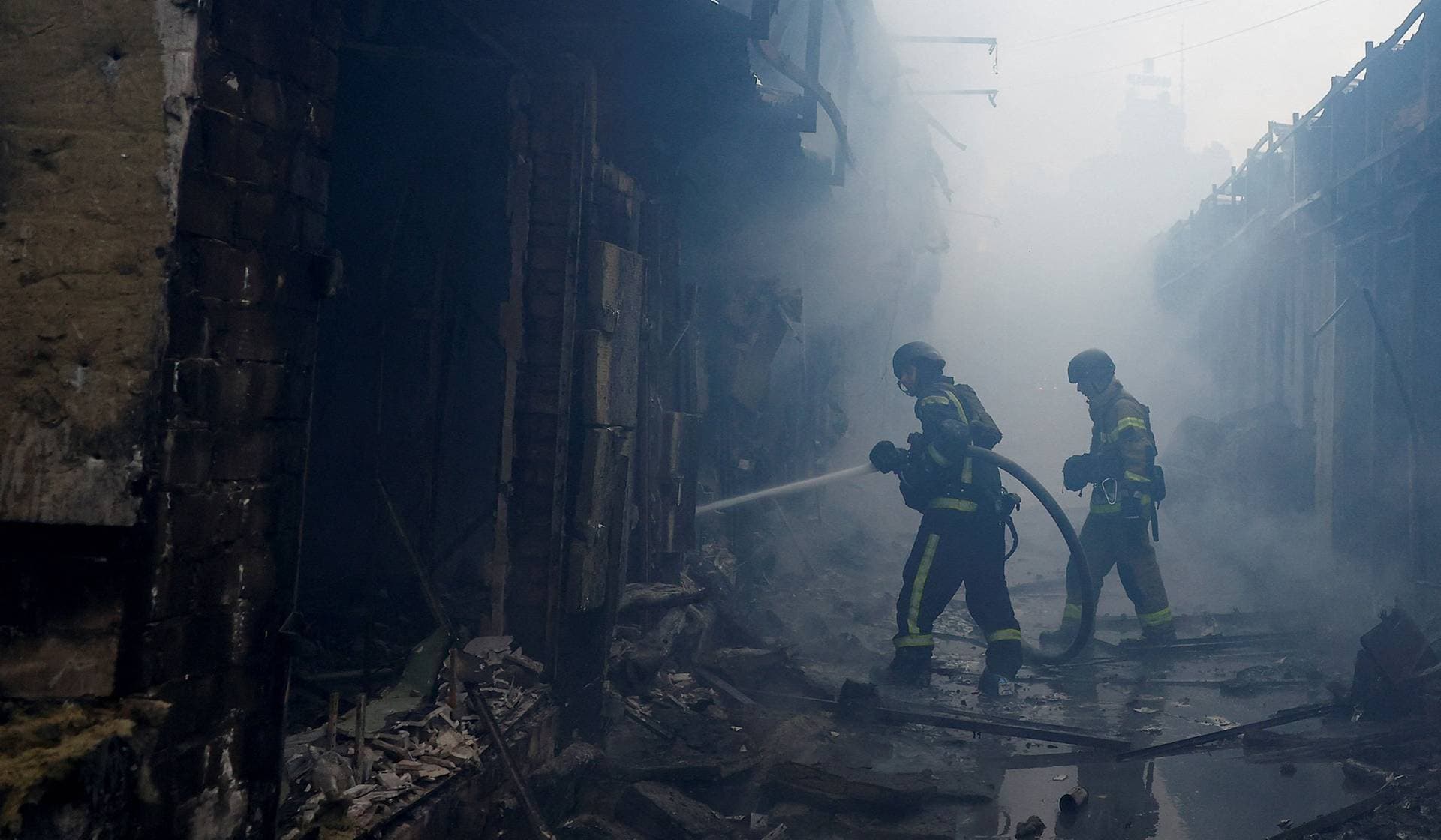 Firefighters work at the site of a market which was hit during Russian missile and drone strikes in Kyiv
