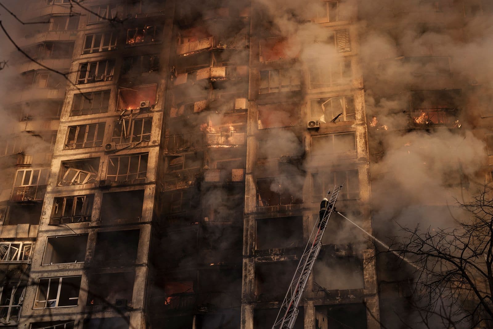 Firefighters work to extinguish flames at an apartment building in Kyiv