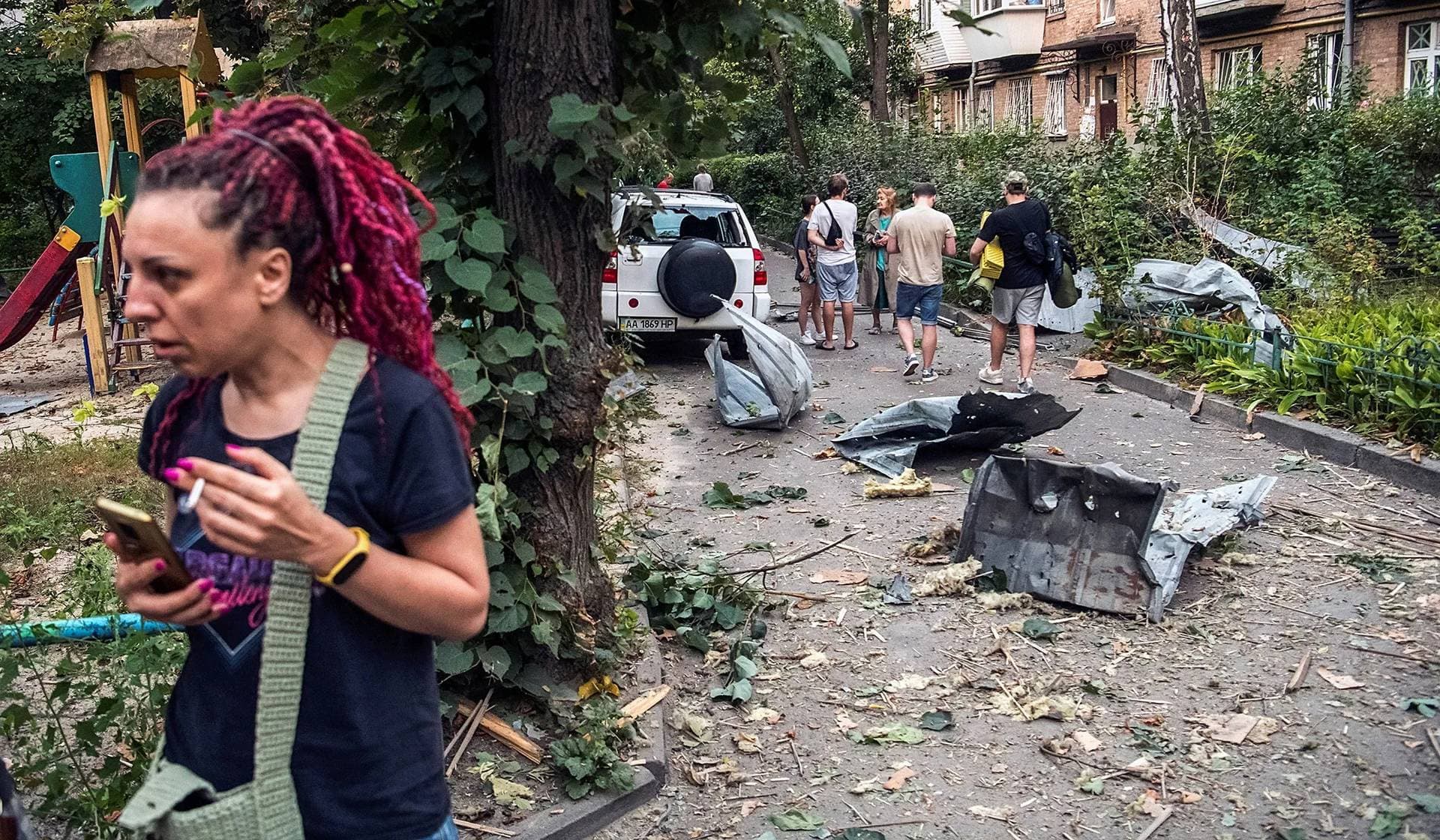 Local residents stand near their apartment building damaged during a Russian missile strike in Kyiv