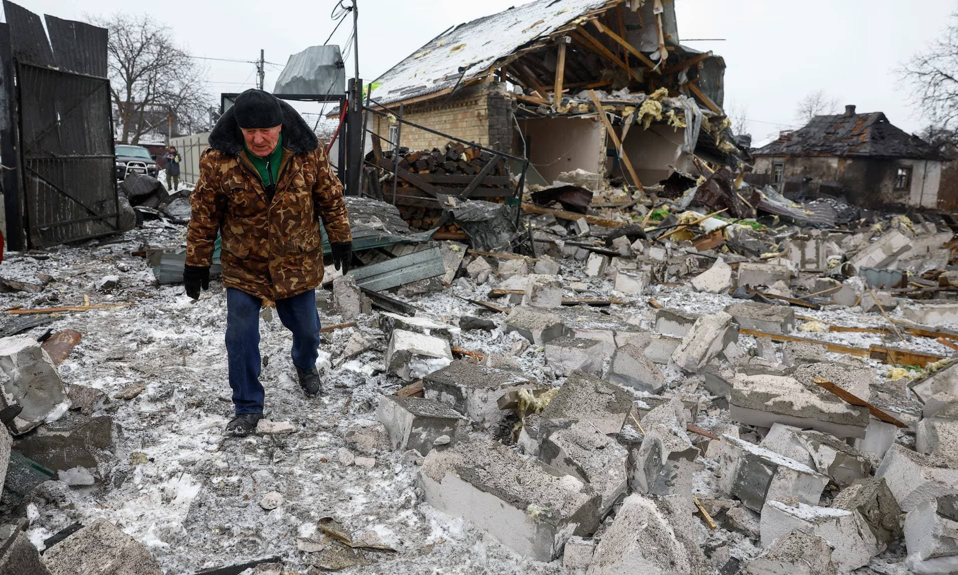 Victor Demchenko walks next to his destroyed house in Kyiv