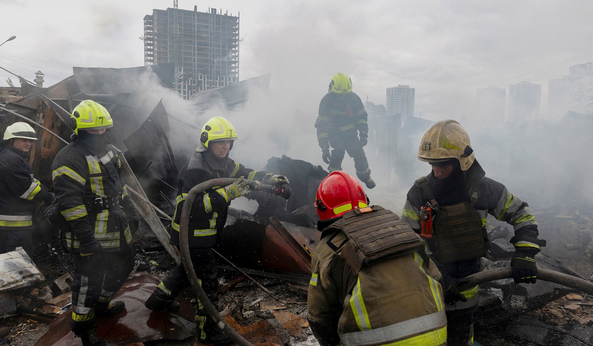 Firefighters work at an impact site where a blast set garages ablaze during Russian drone attacks in a residential neighborhood in Kyiv
