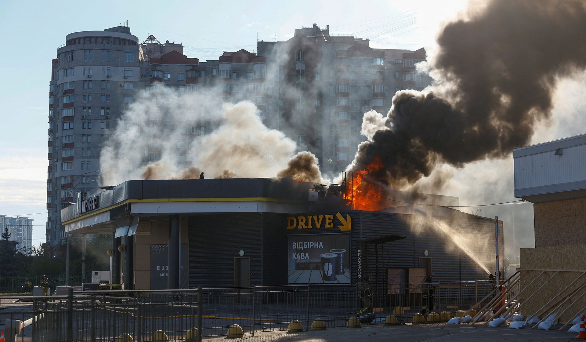 Firefighters work at the site of a gas station hit by a Russian drone strike in Kyiv