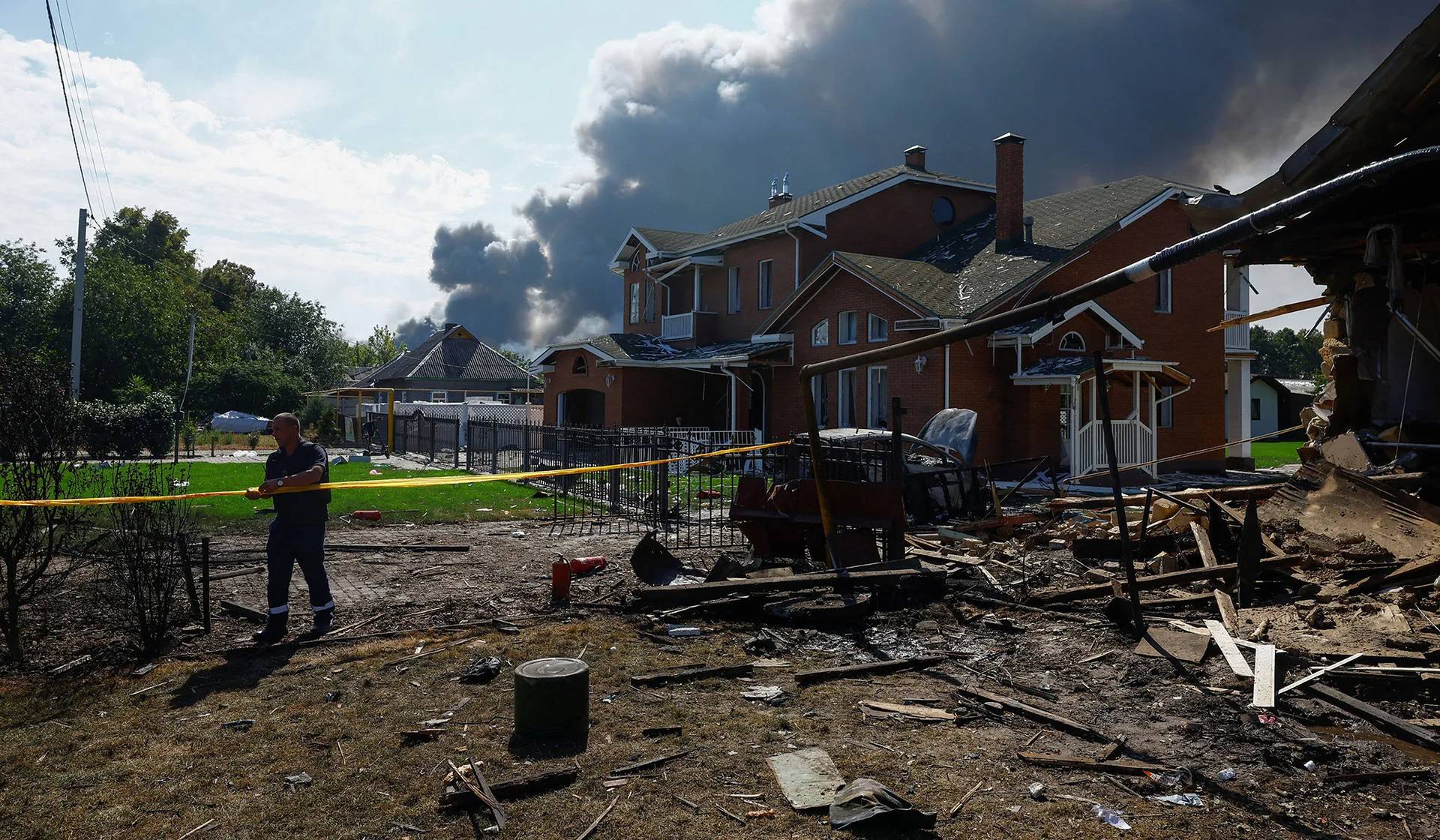 A municipal employee works at the site/Reuters of houses damaged during Russian drone strikes in Kyiv Region