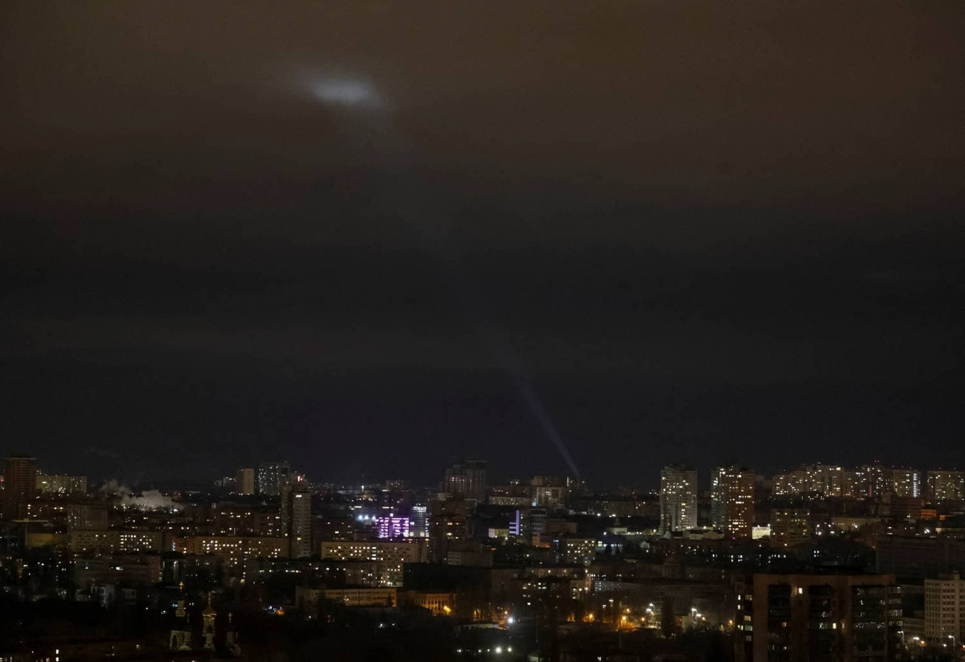 Ukrainian servicemen use a searchlight as they search for drones in the sky over the city during a Russian drone strike in Kyiv