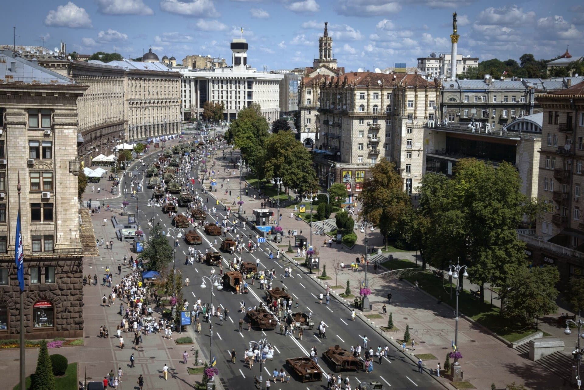 People look at a large column of burnt out and captured Russian tanks and infantry carriers in Kyiv