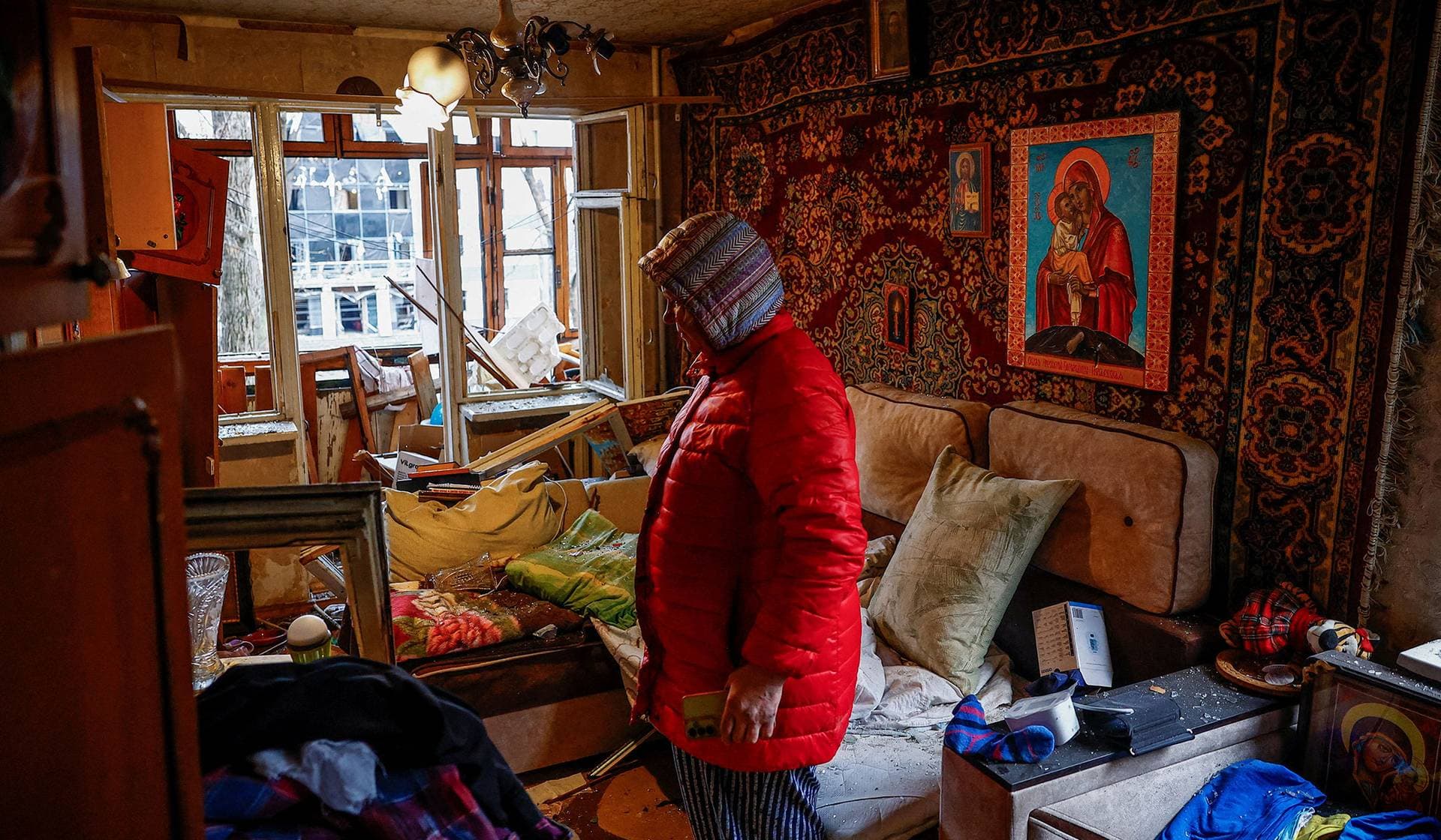 Yana stands in her apartment, damaged during a Russian missile strike in Kyiv