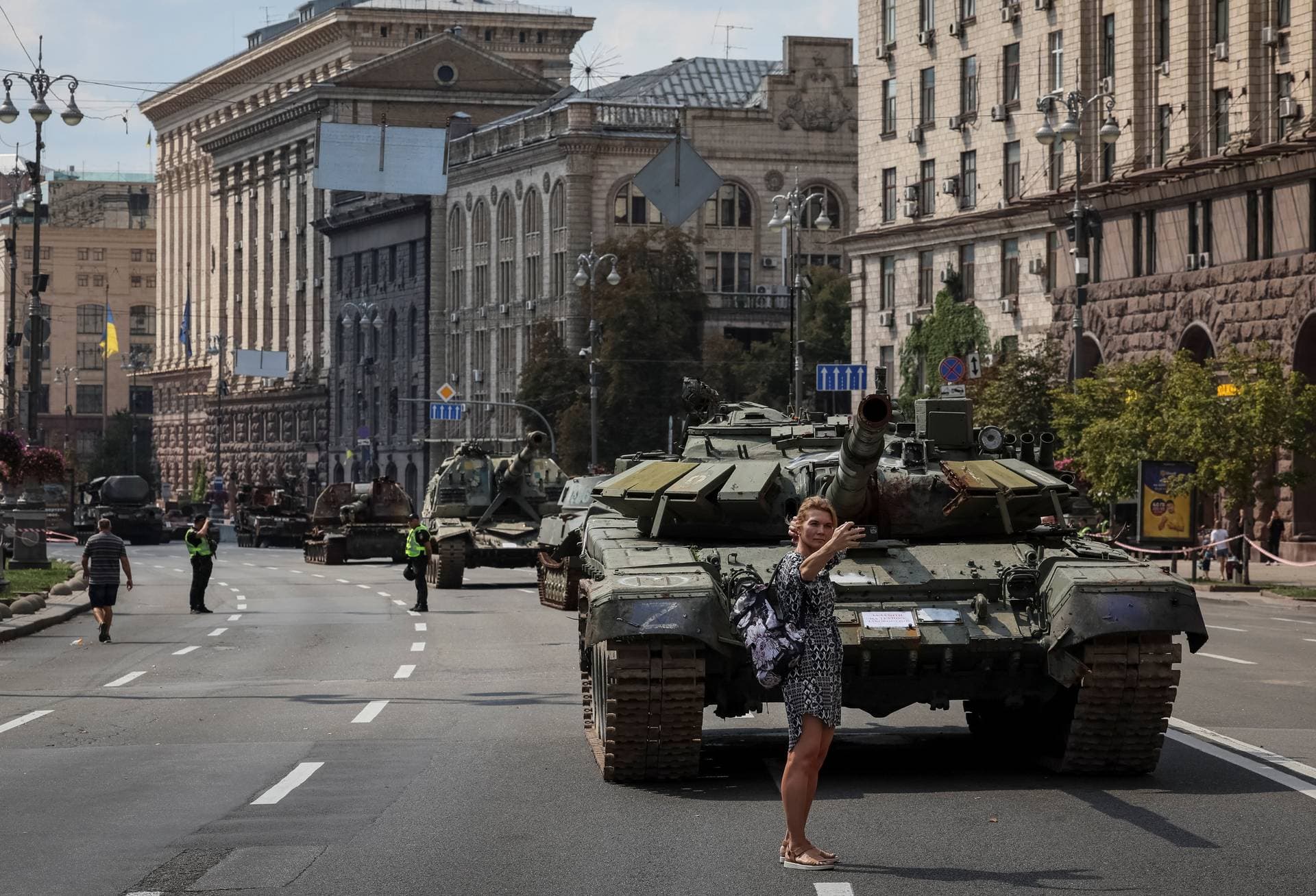 A woman takes a picture as she attends an exhibition displaying destroyed Russian military vehicles in central Kyiv