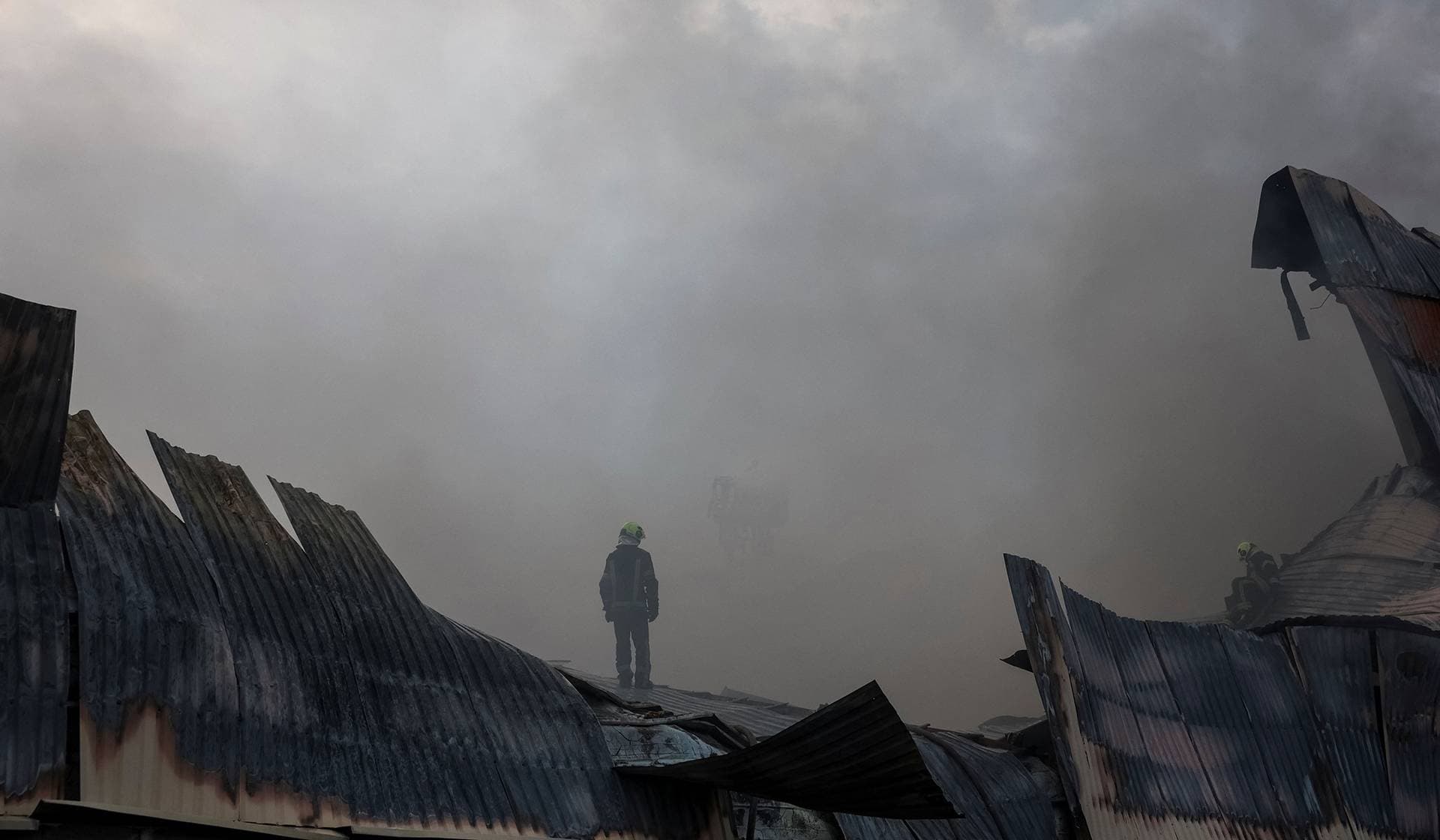 A firefighter works at a site of a food warehouse hit by Russian missile strike in Kyiv