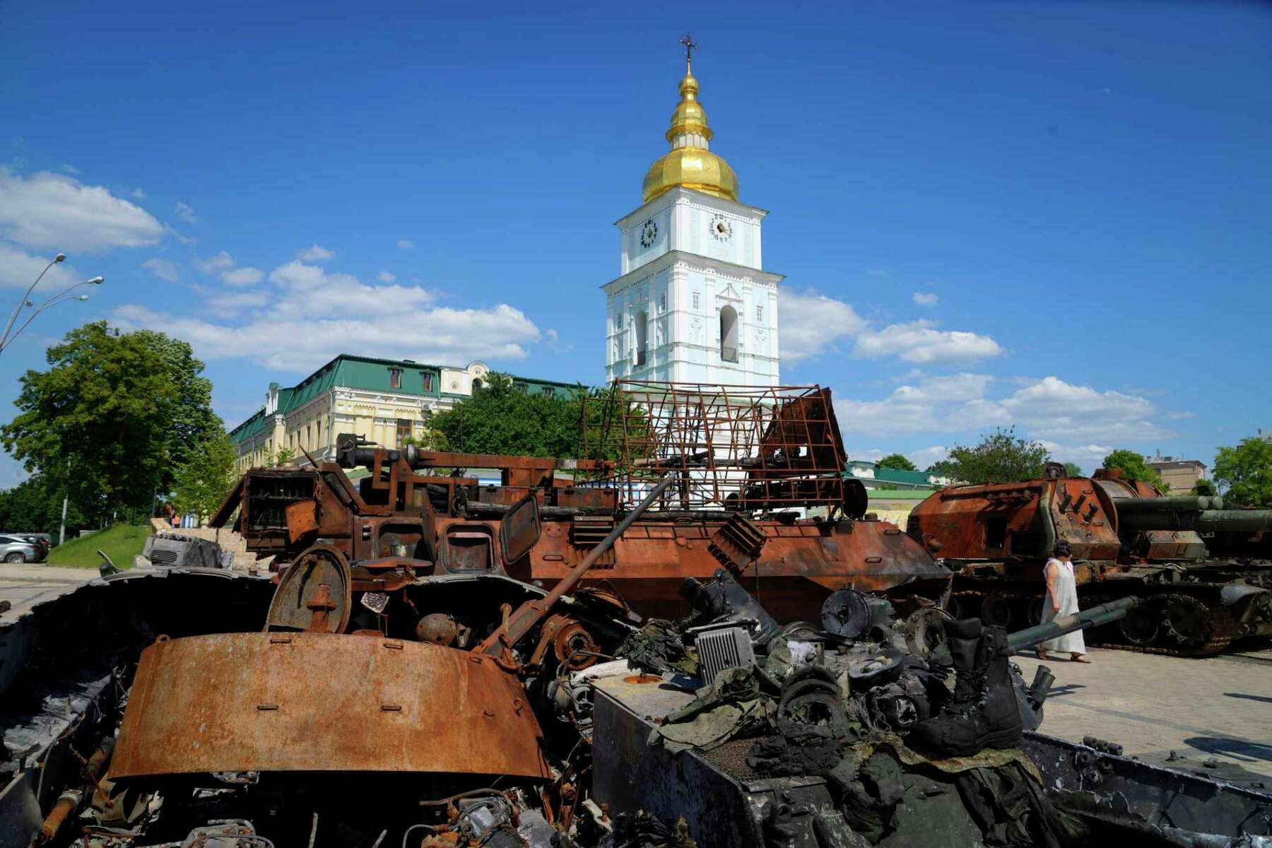 A woman looks at a destroyed Russian tanks installed as a symbol of war in central Kyiv