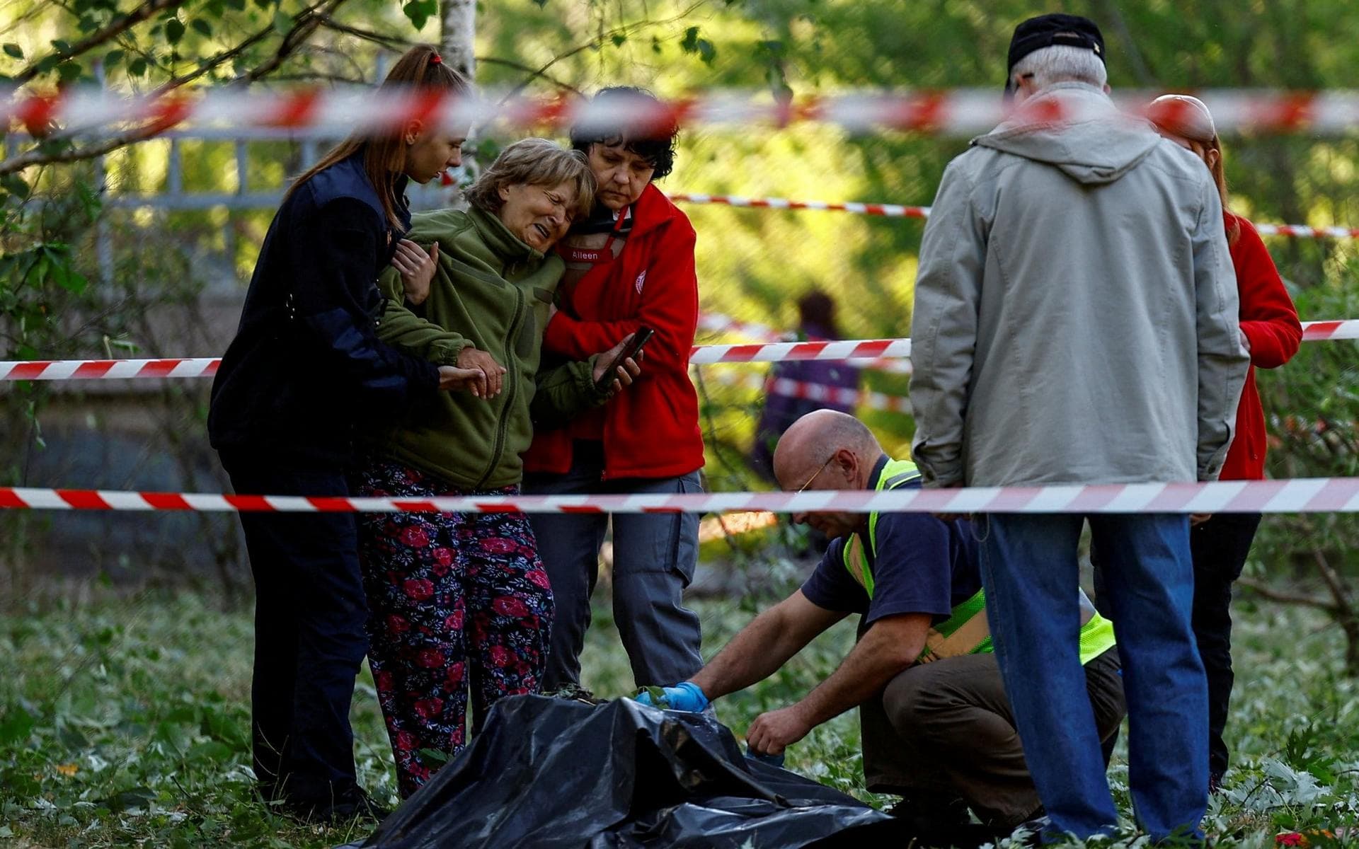 A relative reacts as she looks at the bodies of Olha Ivashko and her daughter Vika in Kyiv