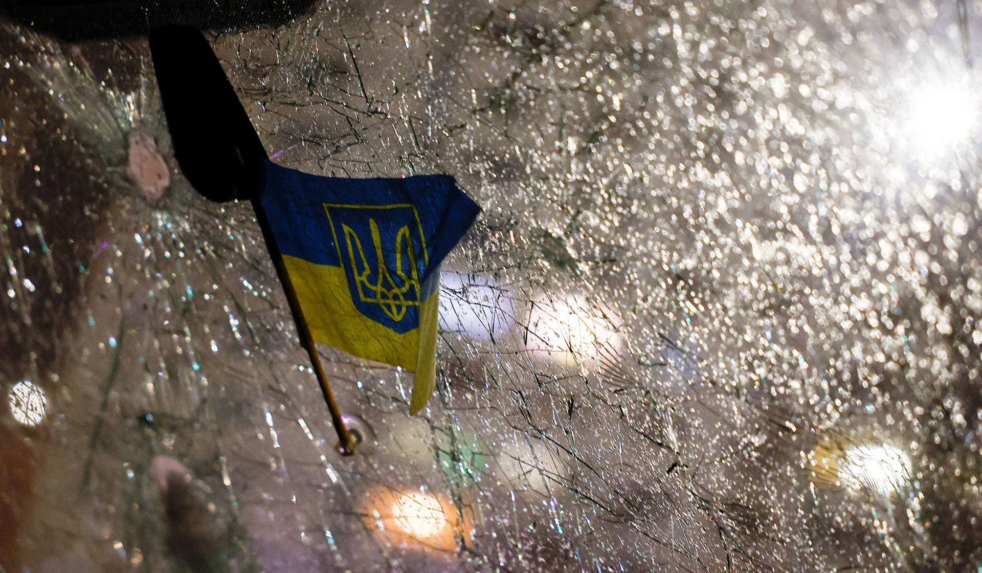 A Ukrainian flag with the Tryzub attached to the windscreen of a damaged ambulance following a Russian drone strike in Kyiv