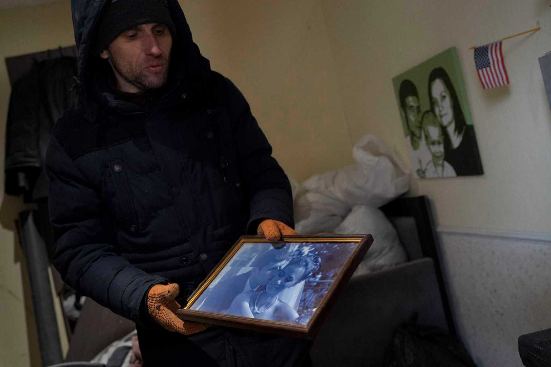 Serhii Kaharlytskyi showing his wedding photo from 16 years ago in his ruined home in Kyiv