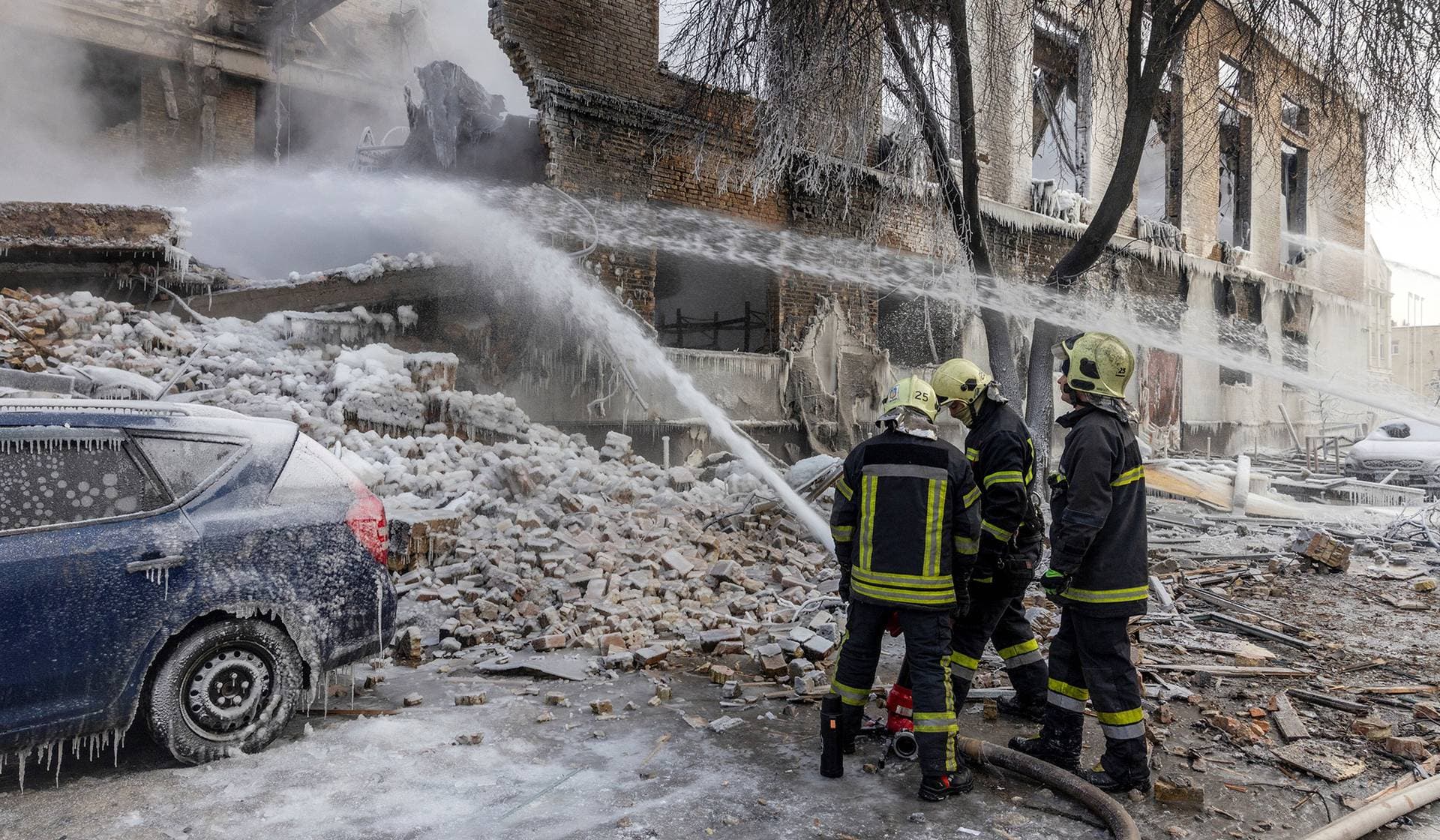 Firefighters work at the site of a building that was hit by a Russian drone in Kyiv