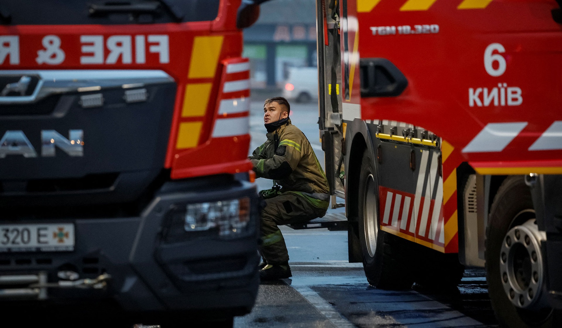 A rescuer takes a break as he works at the site of a shopping center hit by a Russian missile attack in Kyiv