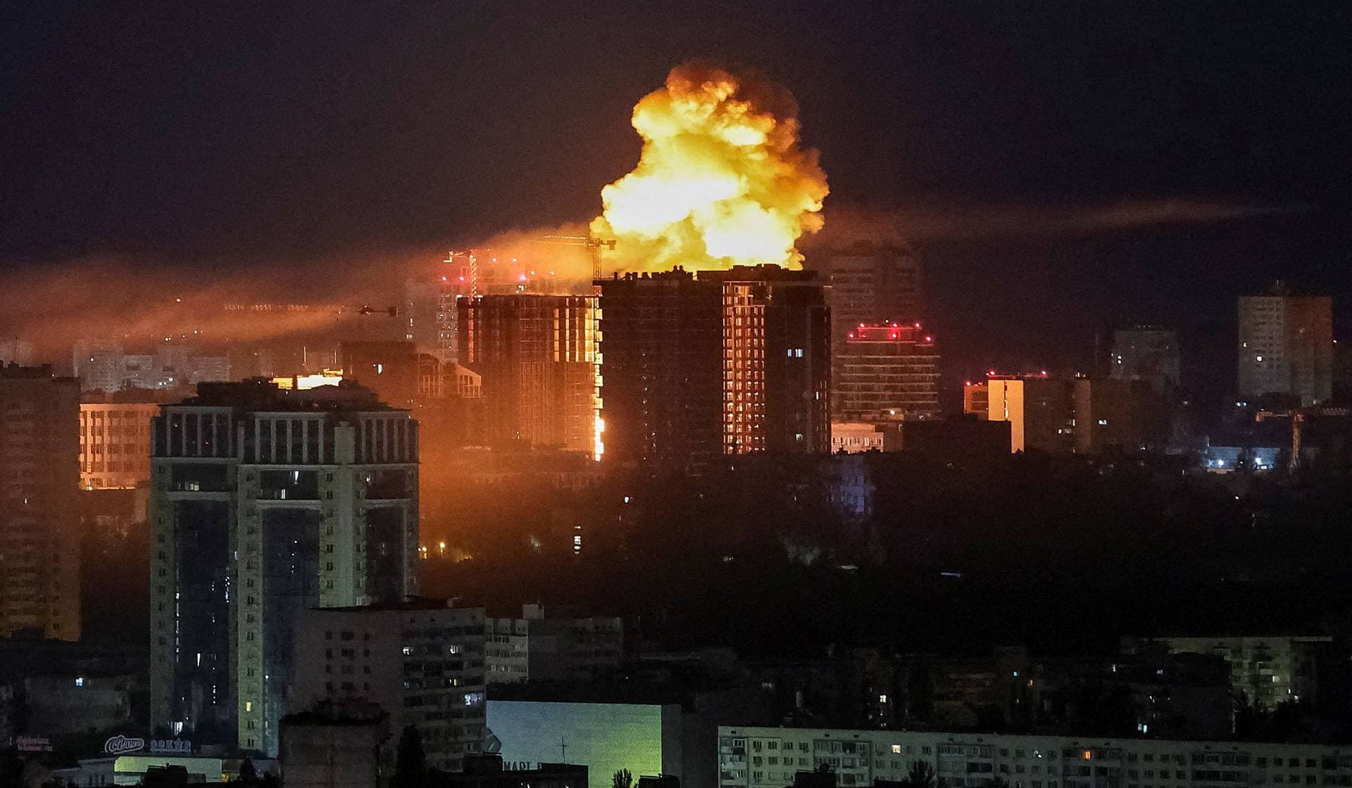 An explosion lights up the sky over the city during a Russian missile and drone strike in Kyiv