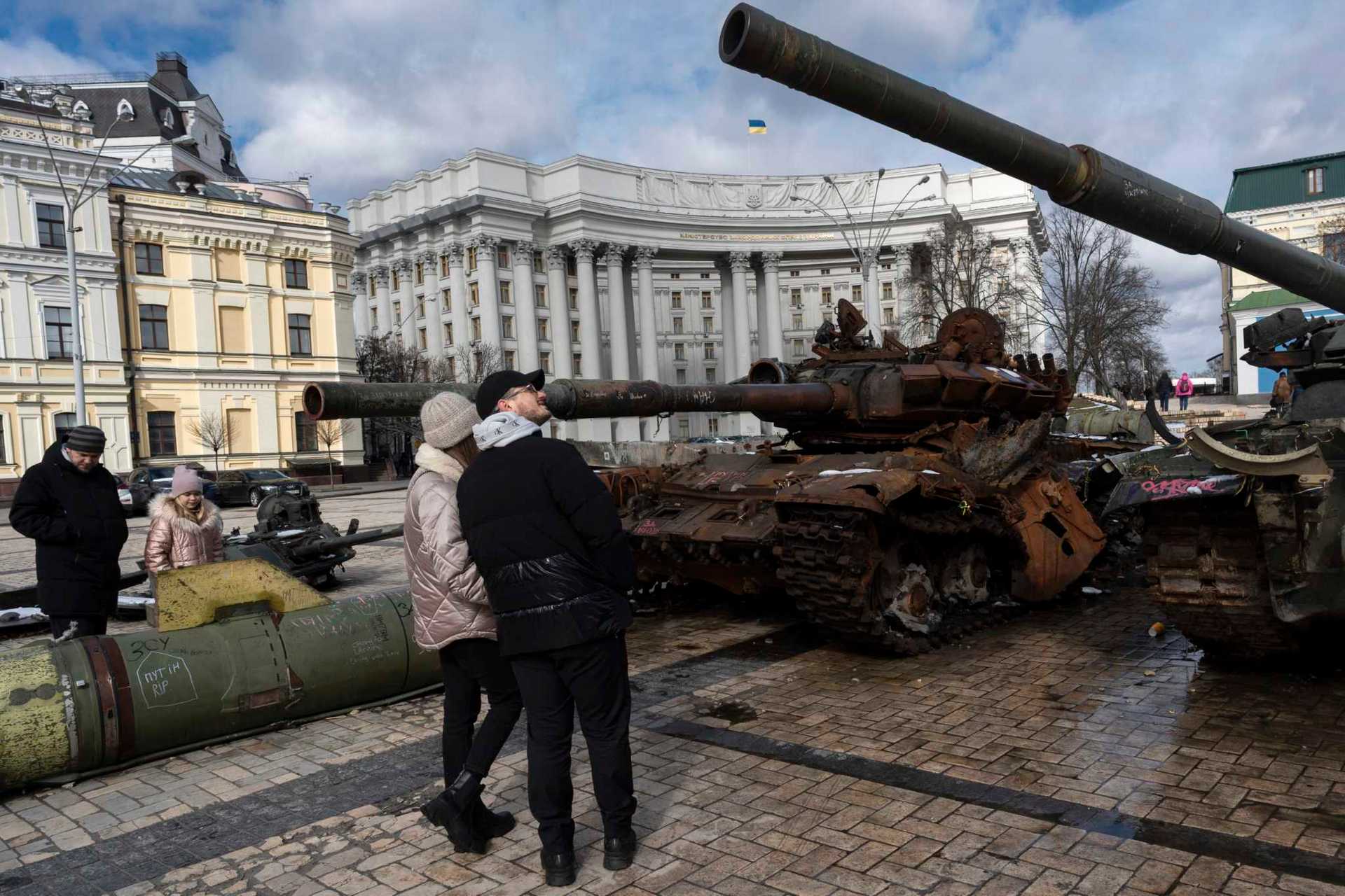 People watch destroyed Russian tanks and armoured vehicles on display near the St. Michael's Cathedral in downtown Kyiv