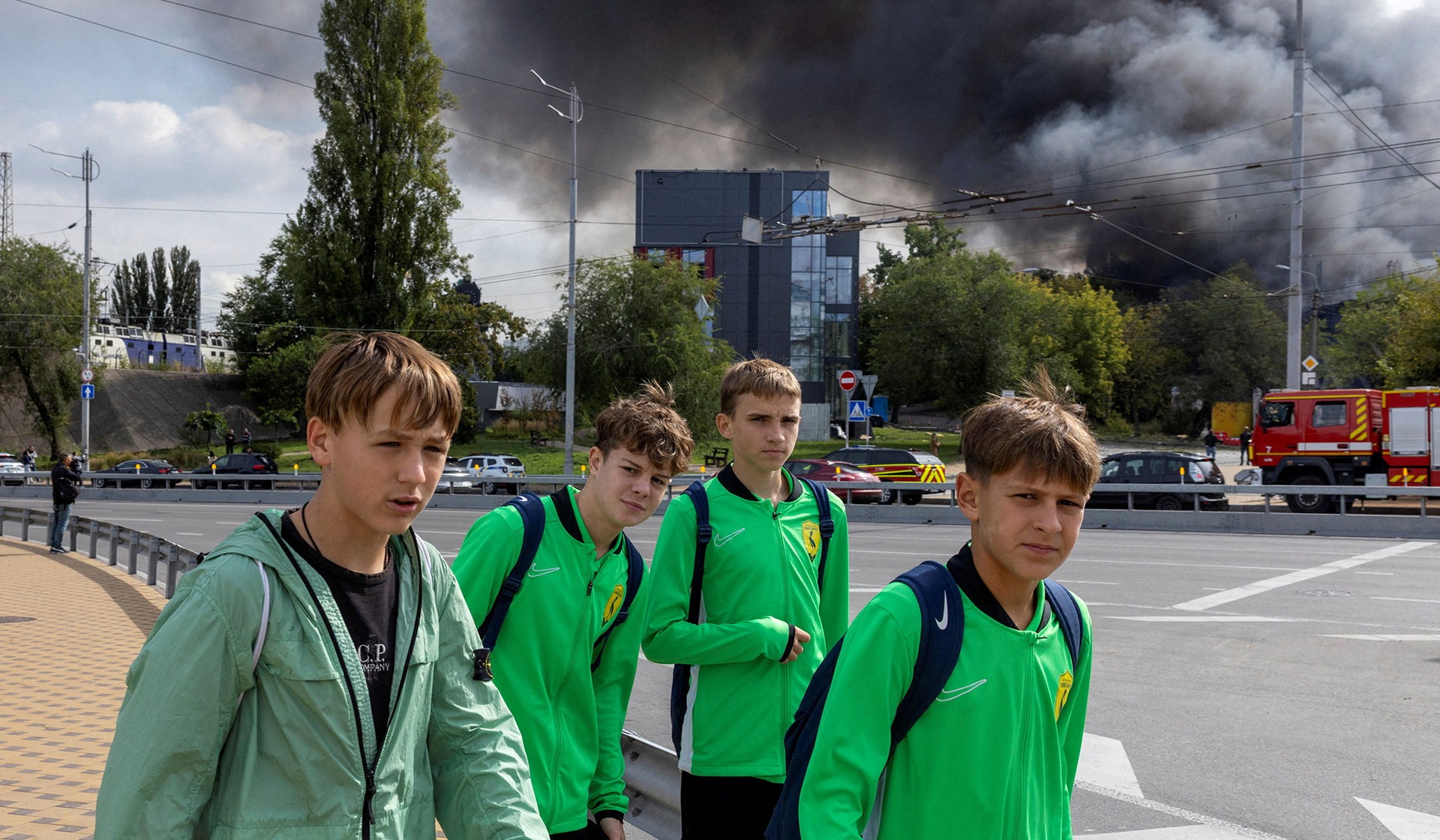 Youths walk near a building that caught fire after being struck by a Russian drone in Kyiv, Ukraine, September 23, 2026.
