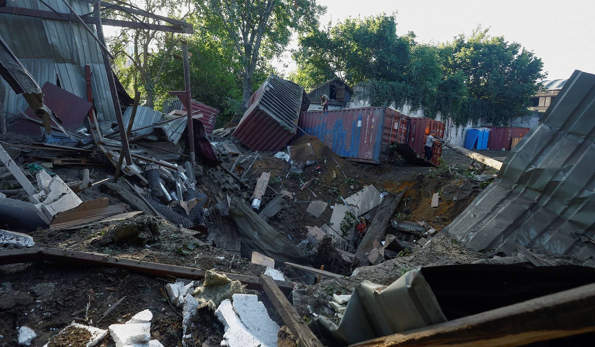 An employee removes debris at the compound of a City Children's Clinical Infectious Disease Hospital, hit by an overnight missile strike, in Kyiv