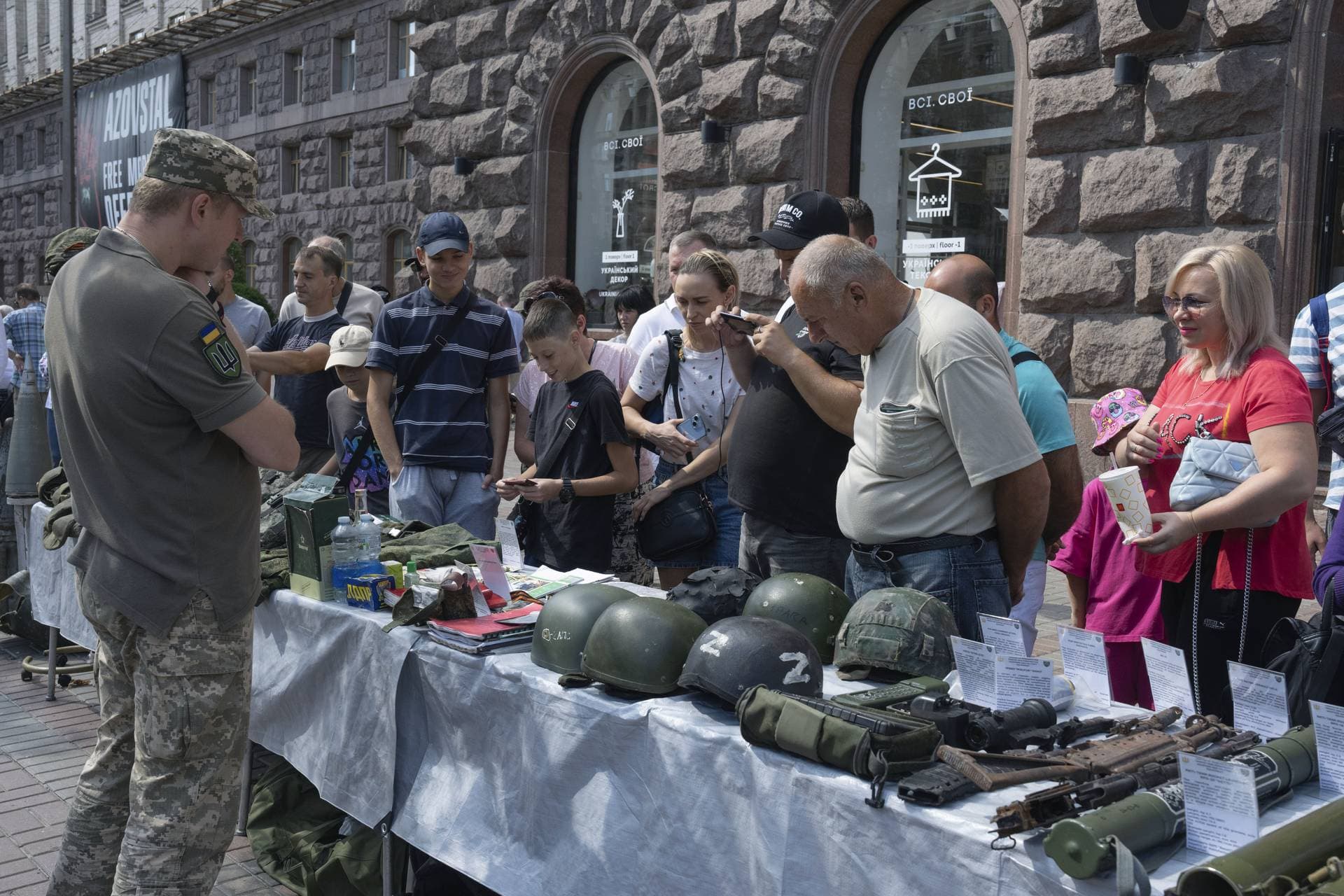 People look at equipment belonging to captured Russian soldiers in Kyiv 