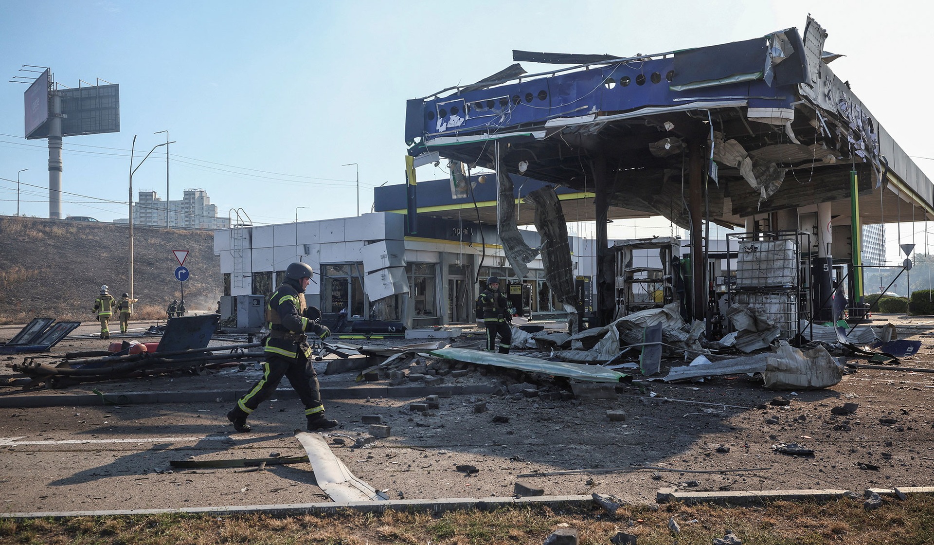 Firefighters work at a site of a gas station hit by a Russian drone strike in Kyiv
