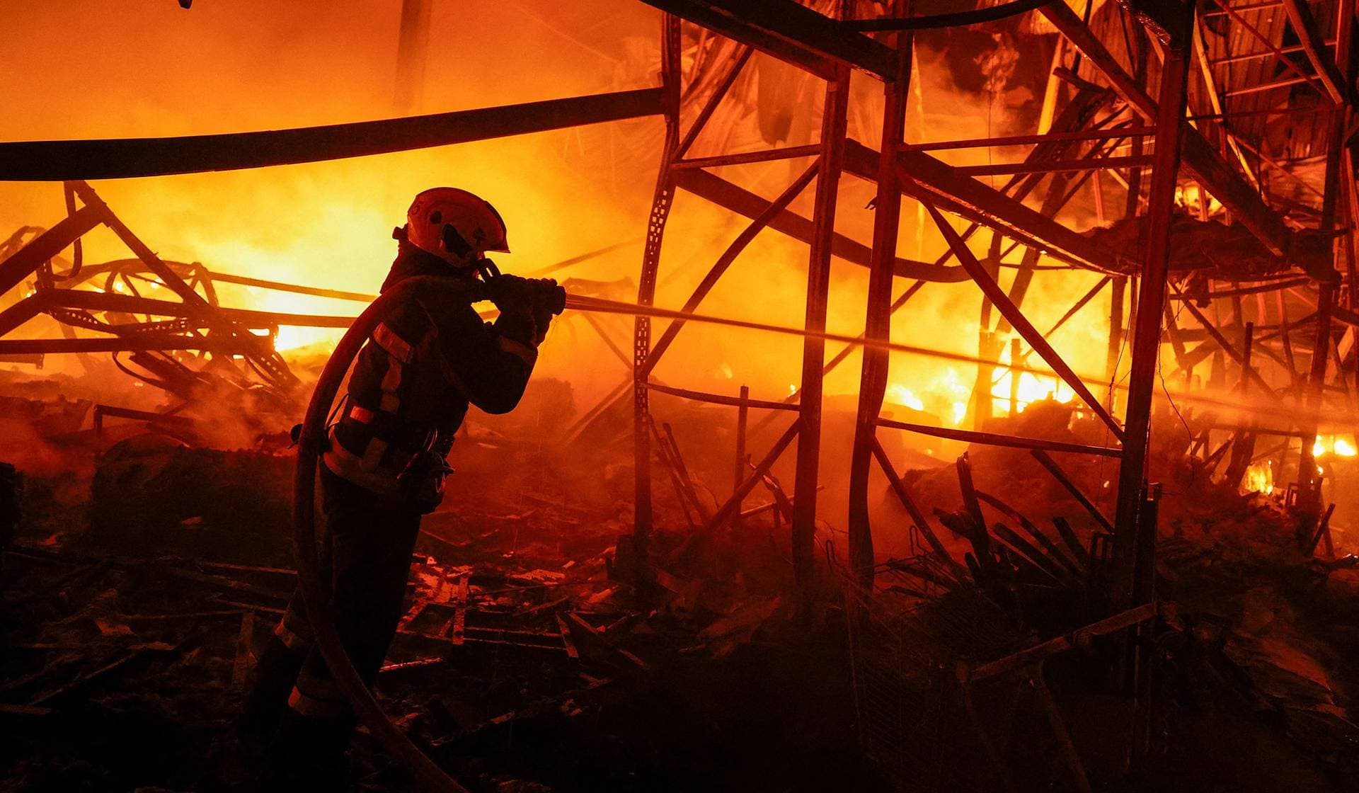 A firefighter works at a compound of a warehouse damaged during Russian missile strikes in Kyiv