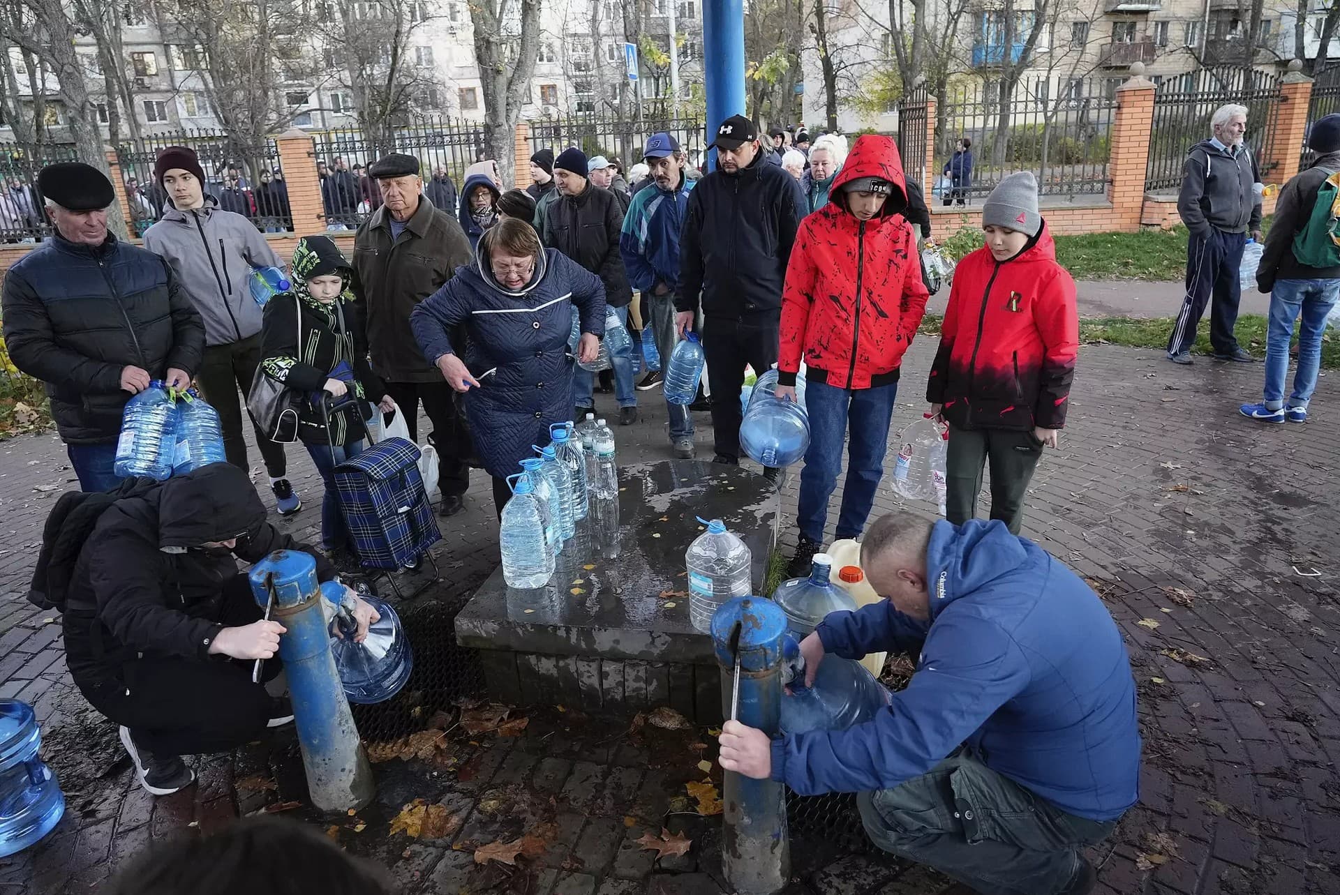 People fill containers with water from public water pumps in Kyiv