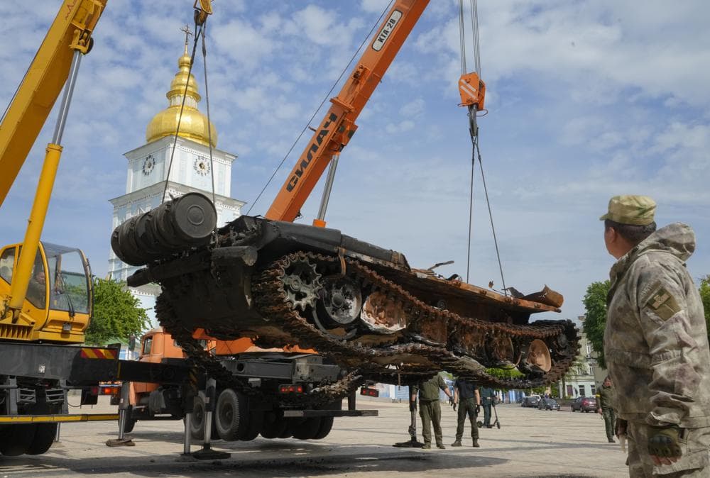 Ukrainian soldiers unload a destroyed Russian tank to install it as a symbol of war in central Kyiv