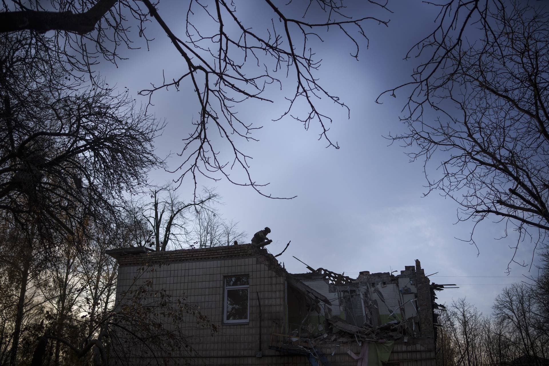 A Ukrainian serviceman stands atop a damaged kindergarten following a Russian drone attack in Kyiv