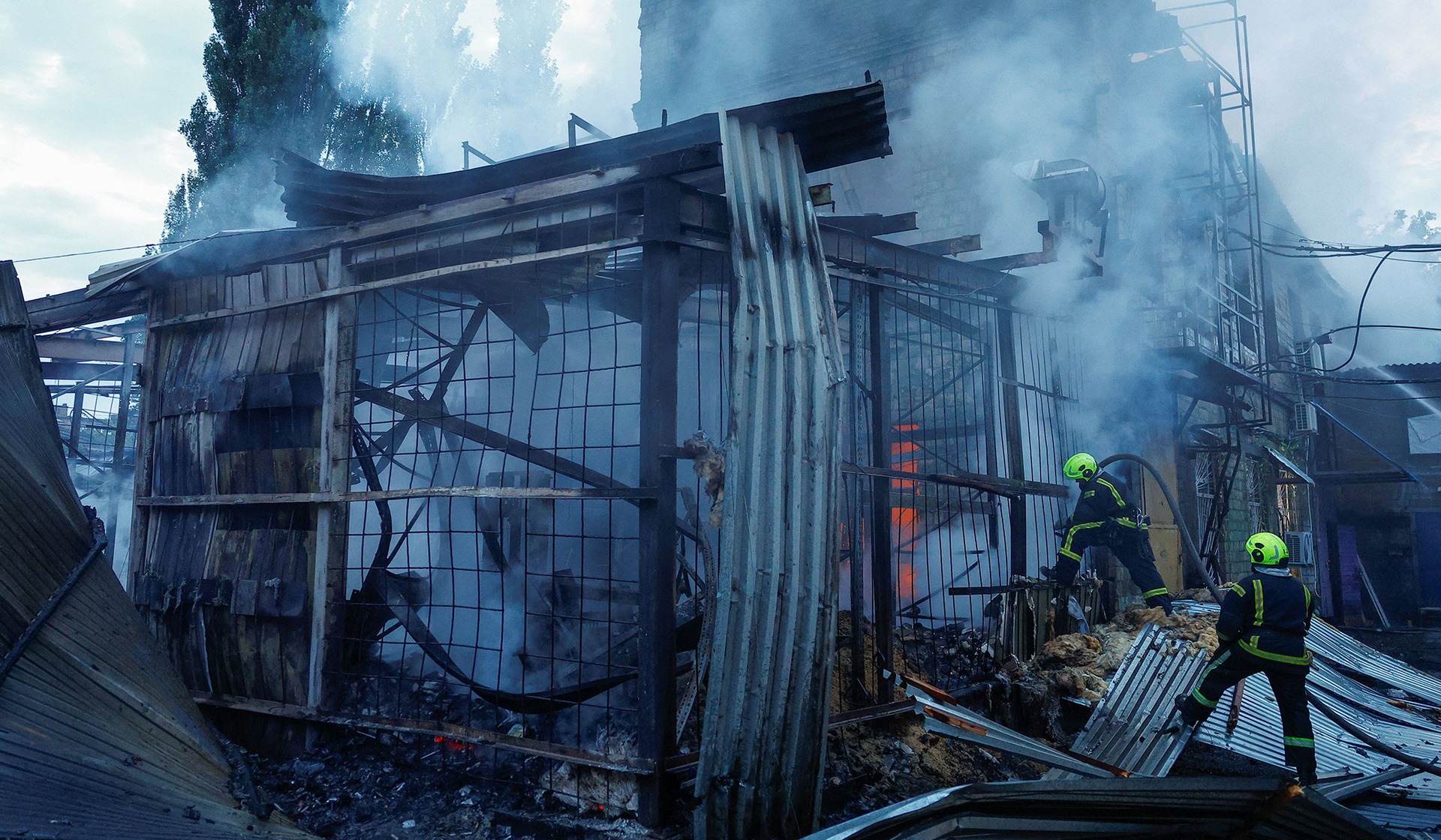 Firefighters work at the site of a non-residential building hit by a Russian drone strike in Kyiv