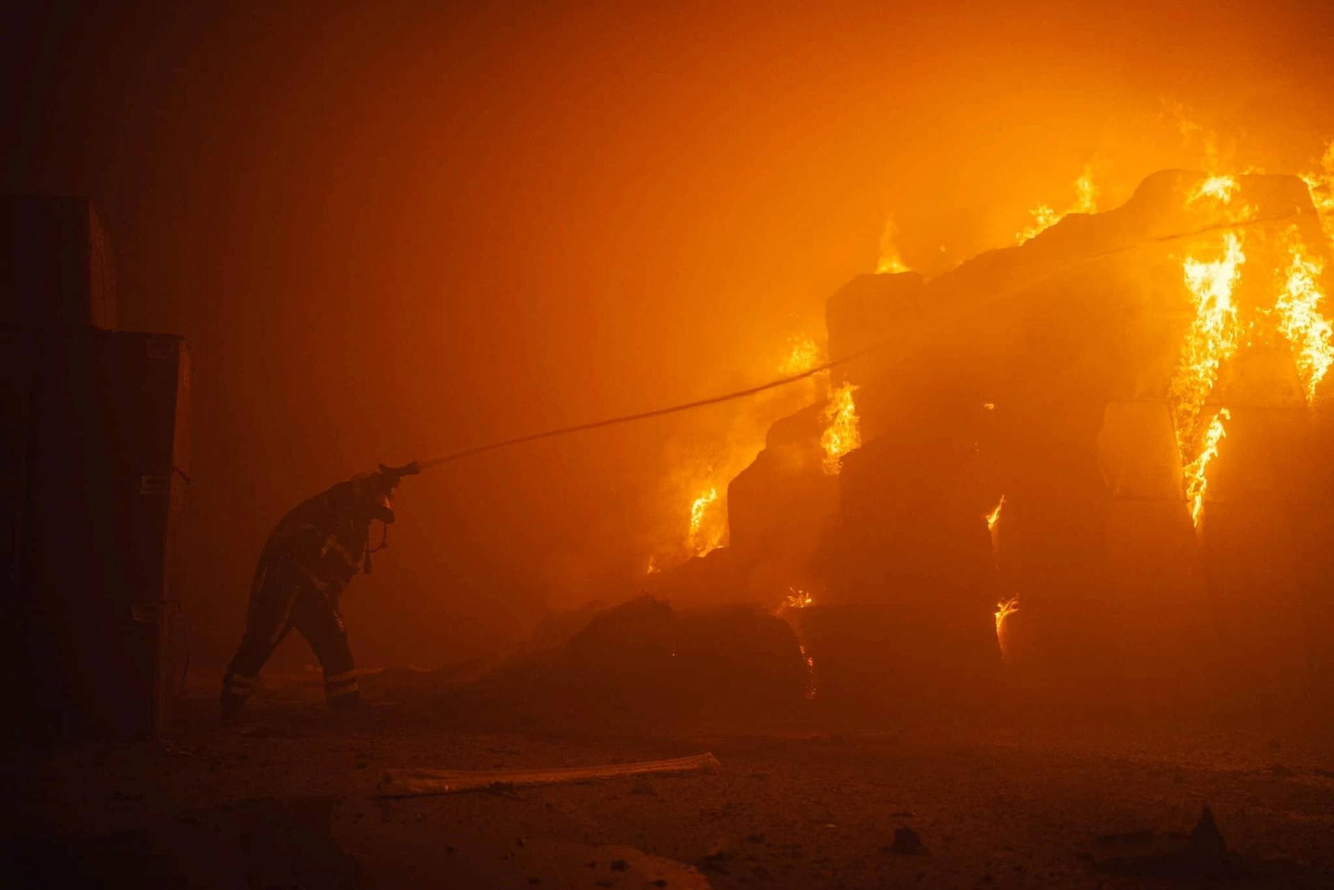 A firefighter works at the site of a tobacco factory damaged during Russian drone strike in Kyiv