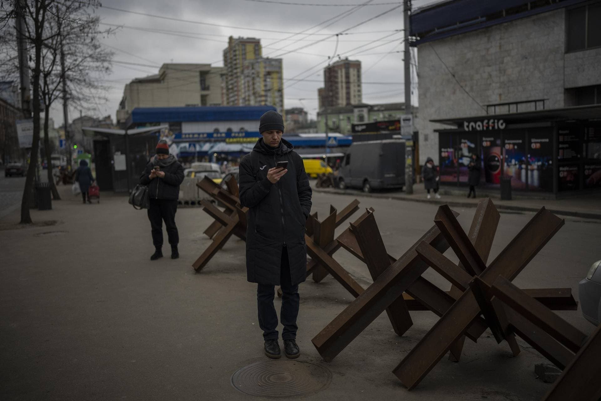 People wait for a bus to arrive in Kyiv