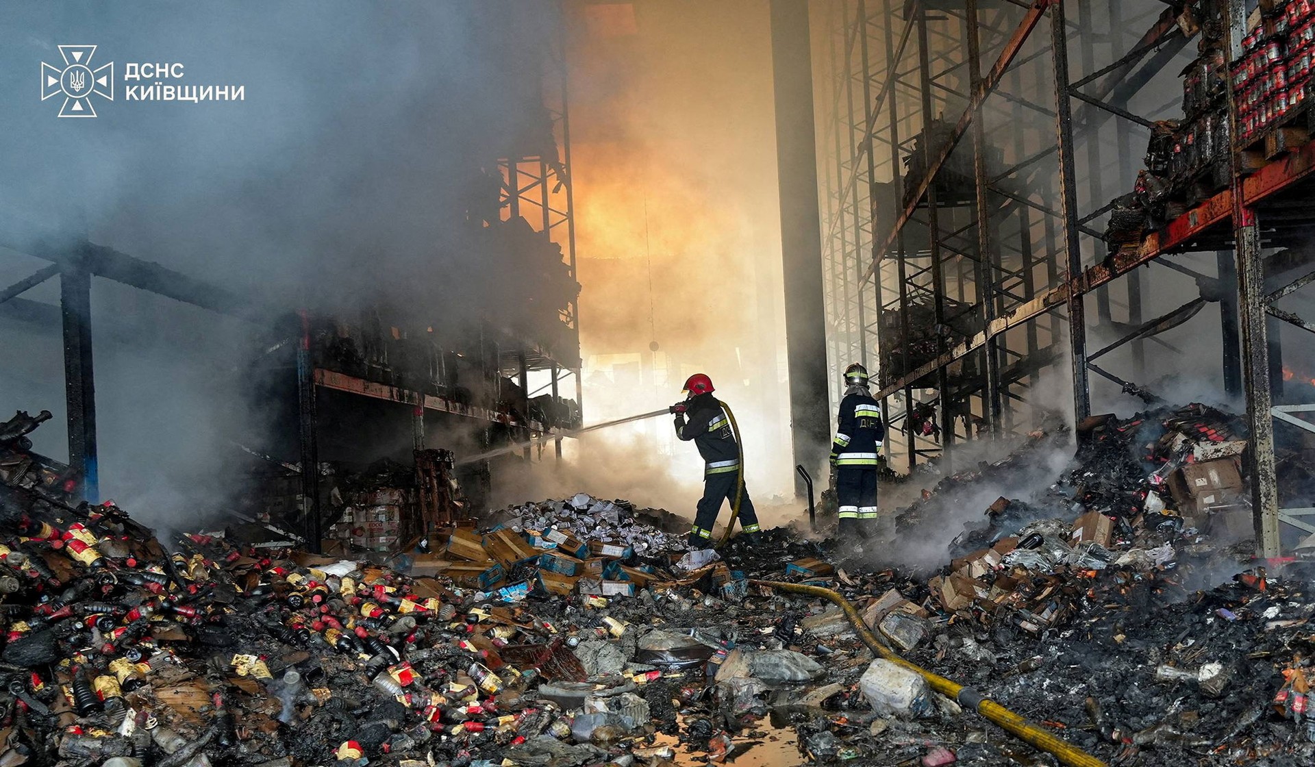 Firefighter work at a site of a destroyed warehouse hit during a Russian drone strike in Kyiv region