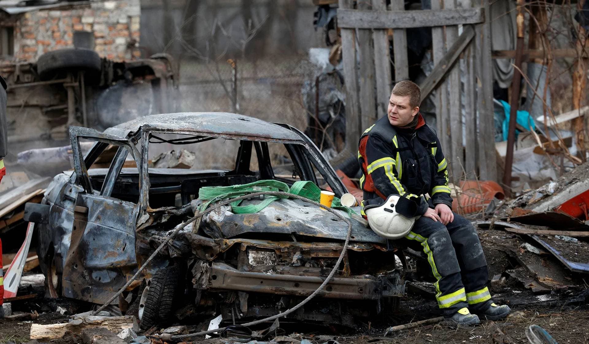 A rescuer rests at a site of a residential house damaged during a Russian missile strike in Kyiv