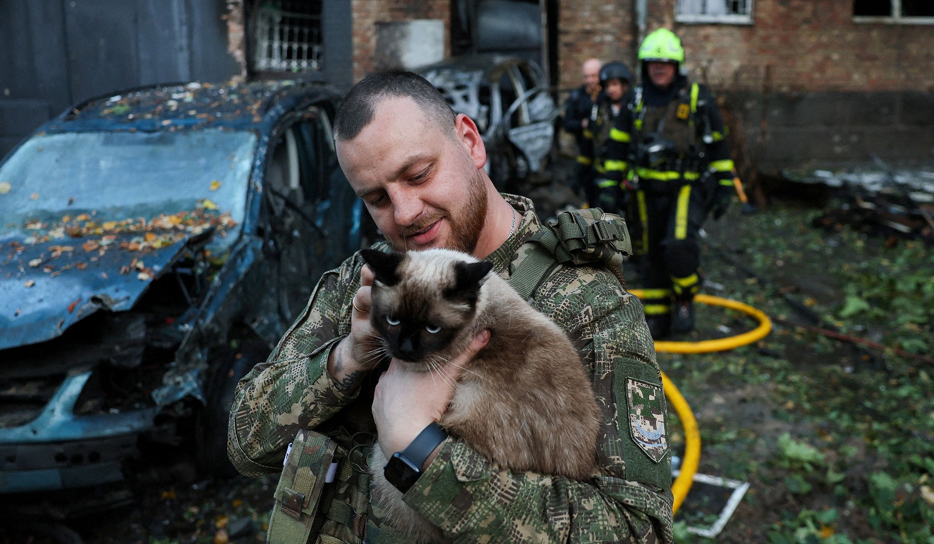 A member of the Ukrainian armed forces holds a cat rescued from an apartment building which was damaged during a Russian drone strike in Kyiv