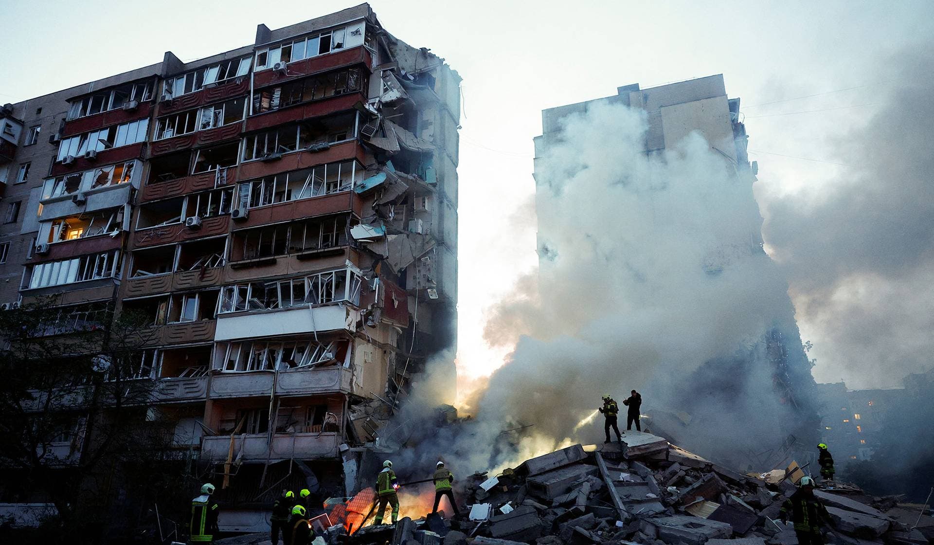 Rescuers search for people under the debris at the site of an apartment building damaged during Russian missile and drone strikes in Kyiv