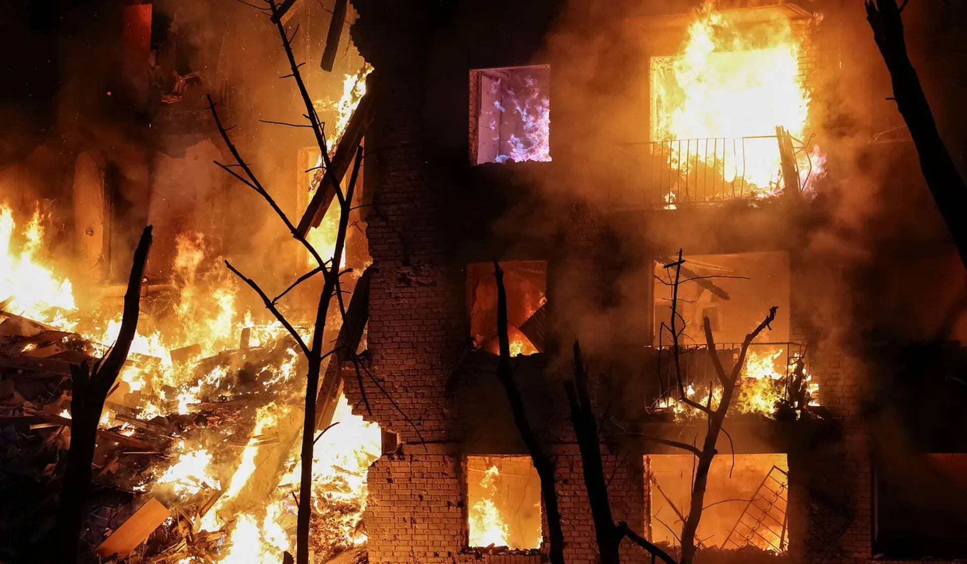 Fire engulfs an apartment building destroyed by a Russian missile and drone strike in Kyiv