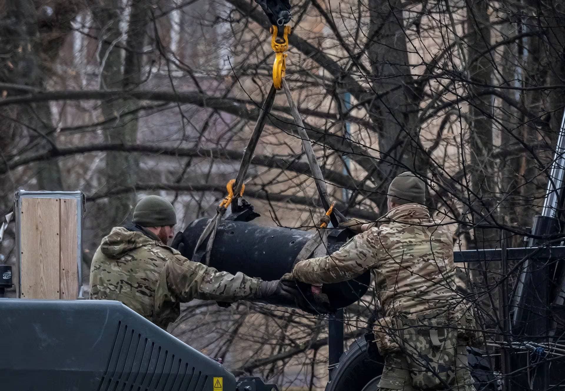 Bomb squad members load a part of a missile on a truck after a Russian missile attack in Kyiv