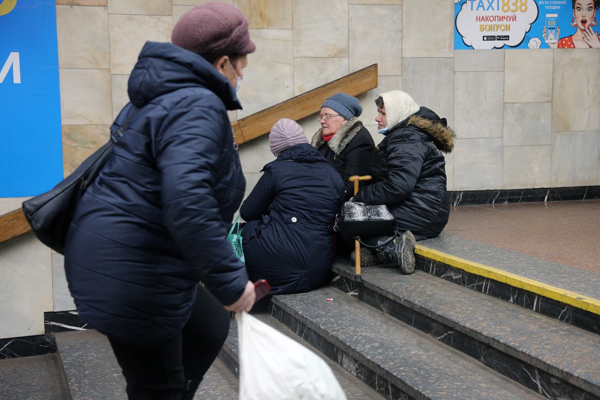 Women sit on the stairs at the subway entrance