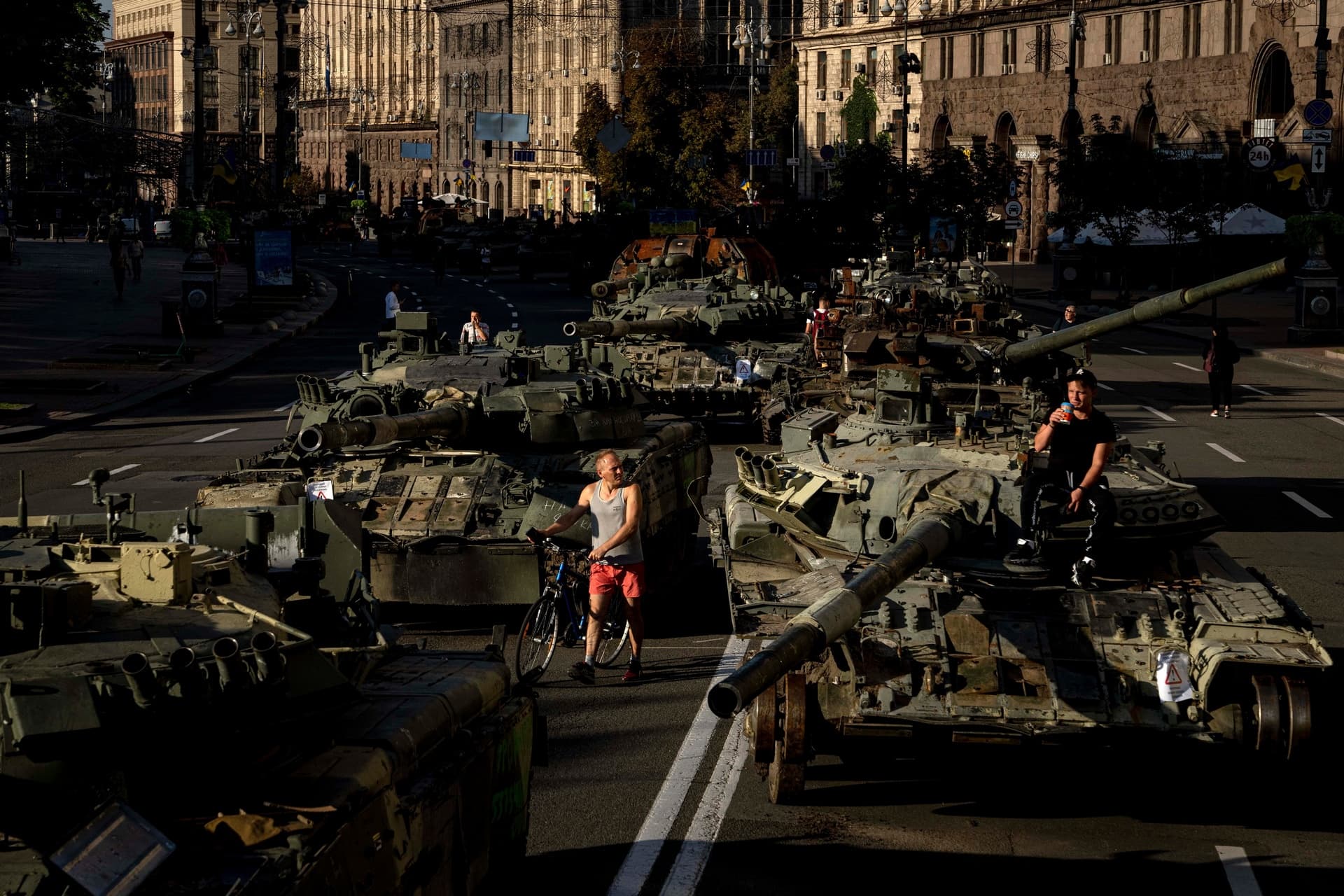 People walk around destroyed Russian military vehicles installed in downtown Kyiv