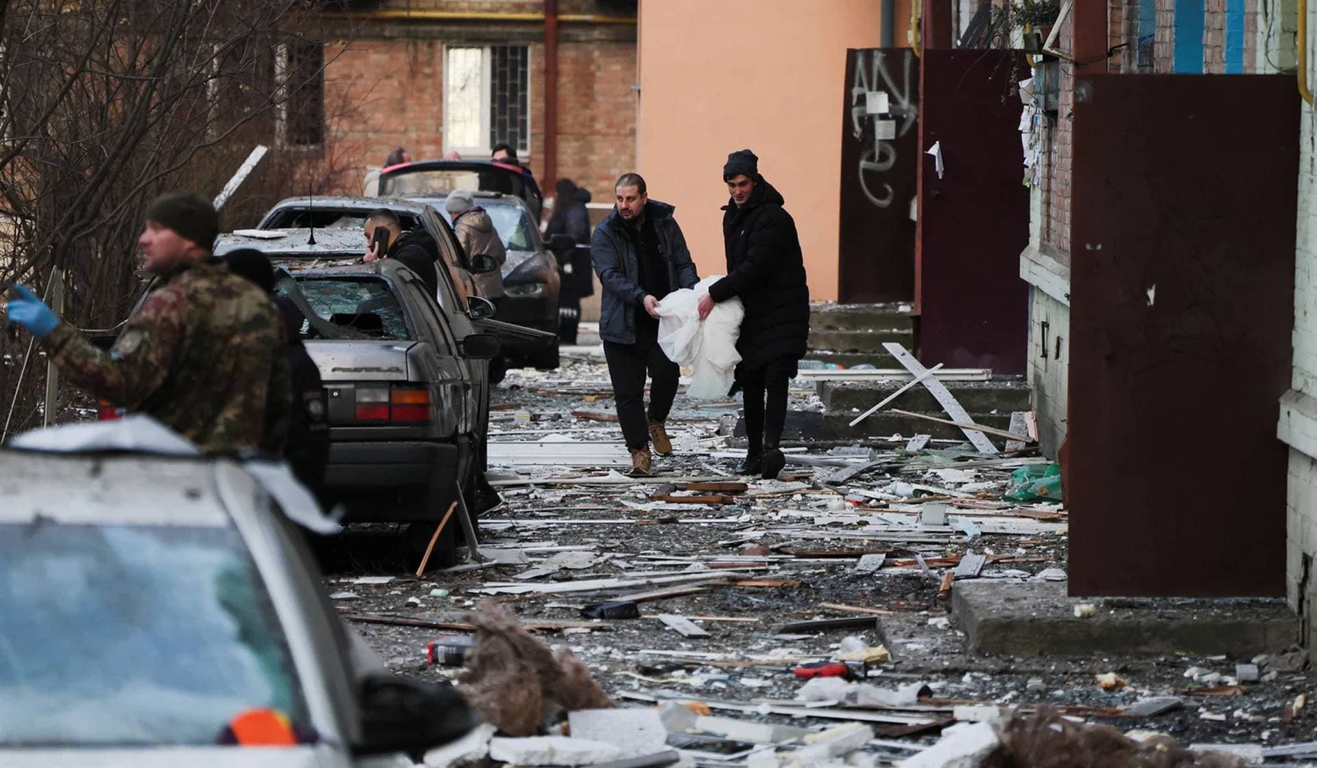 Local residents walk outside a building damaged during a Russian missile strike in Kyiv
