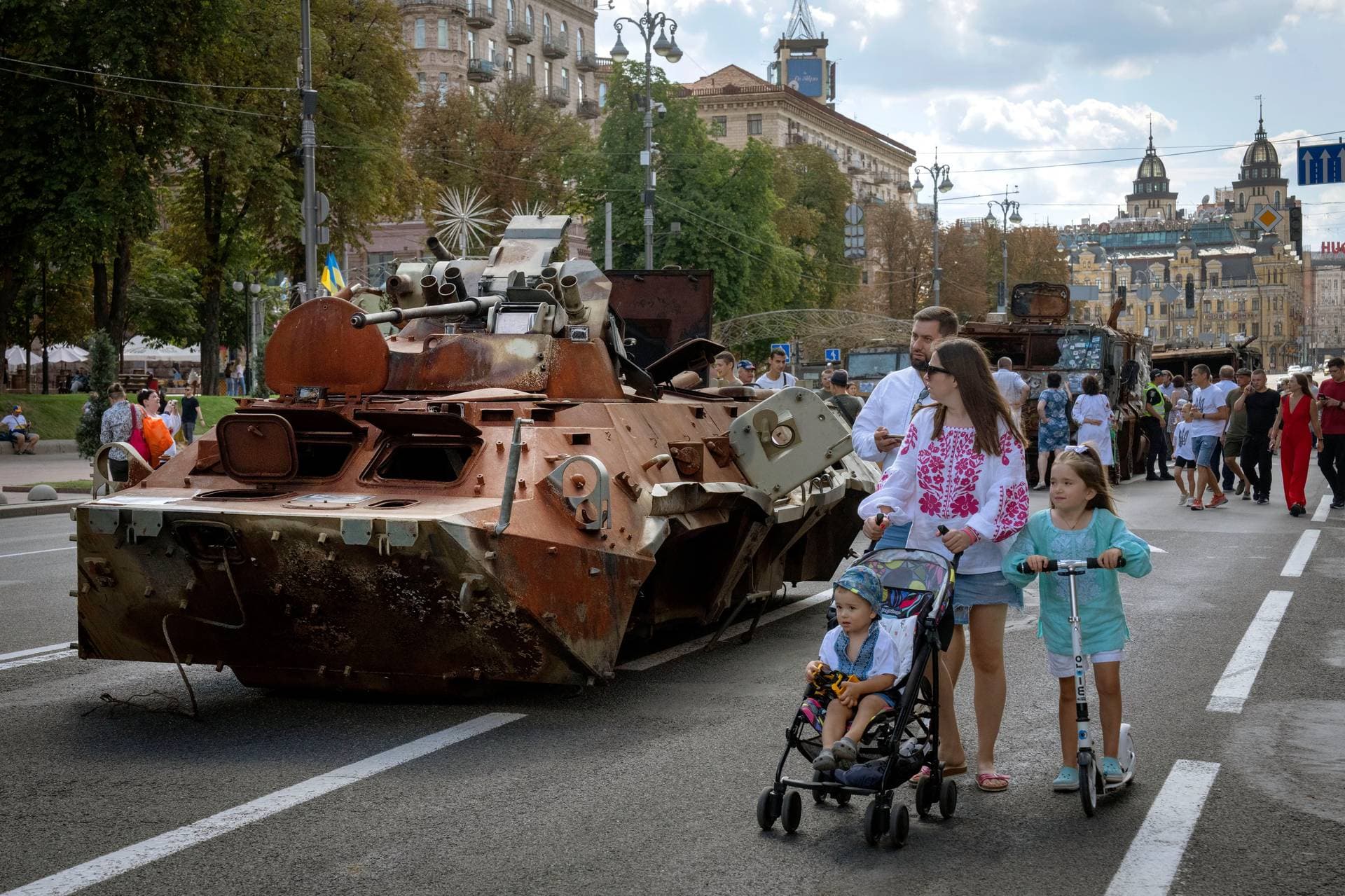 People look at a large column of burnt out and captured Russian tanks and infantry carriers in Kyiv